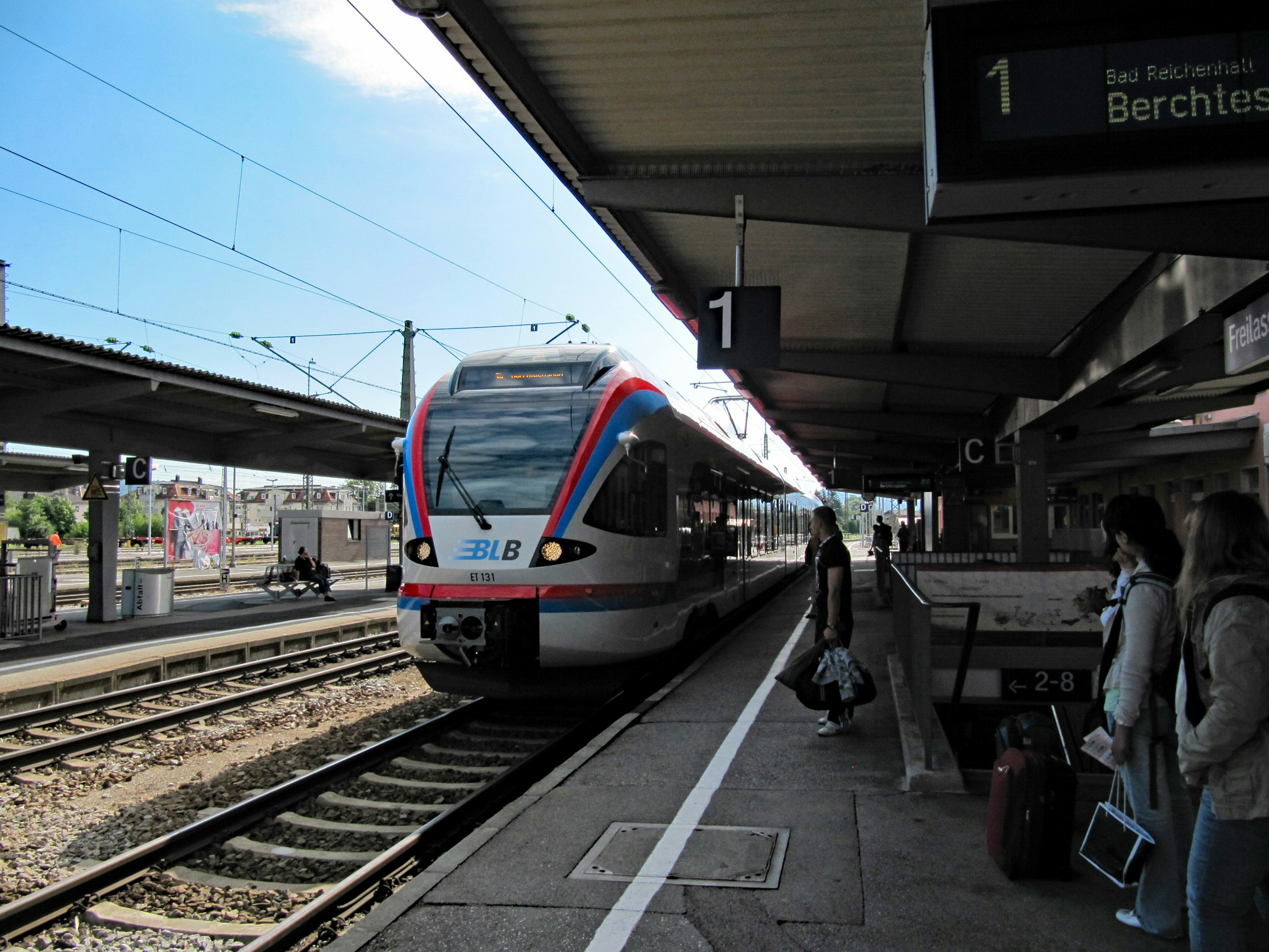 Train arriving at a station platform with passengers waiting