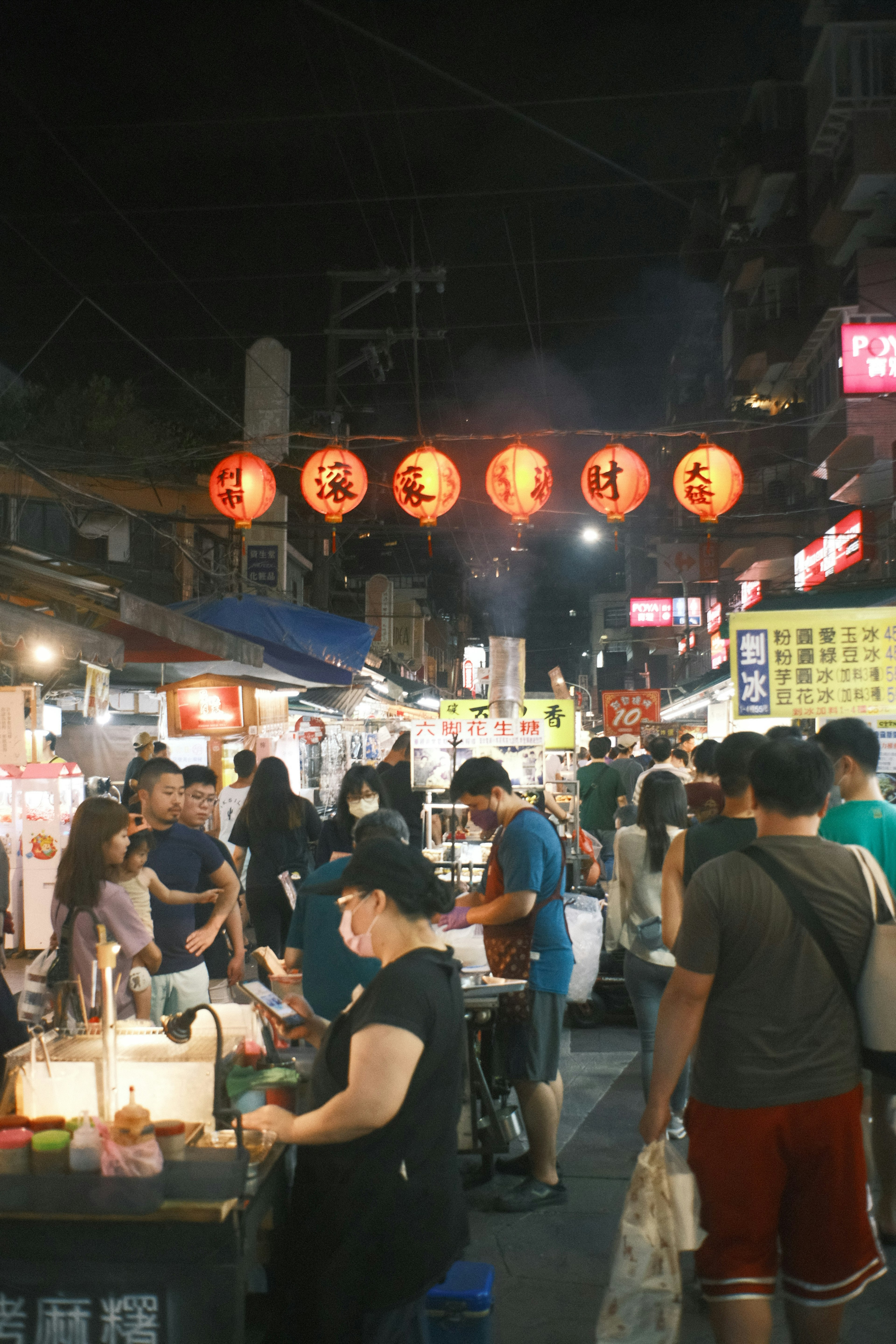 Escena de mercado nocturno animado con faroles rojos y multitudes