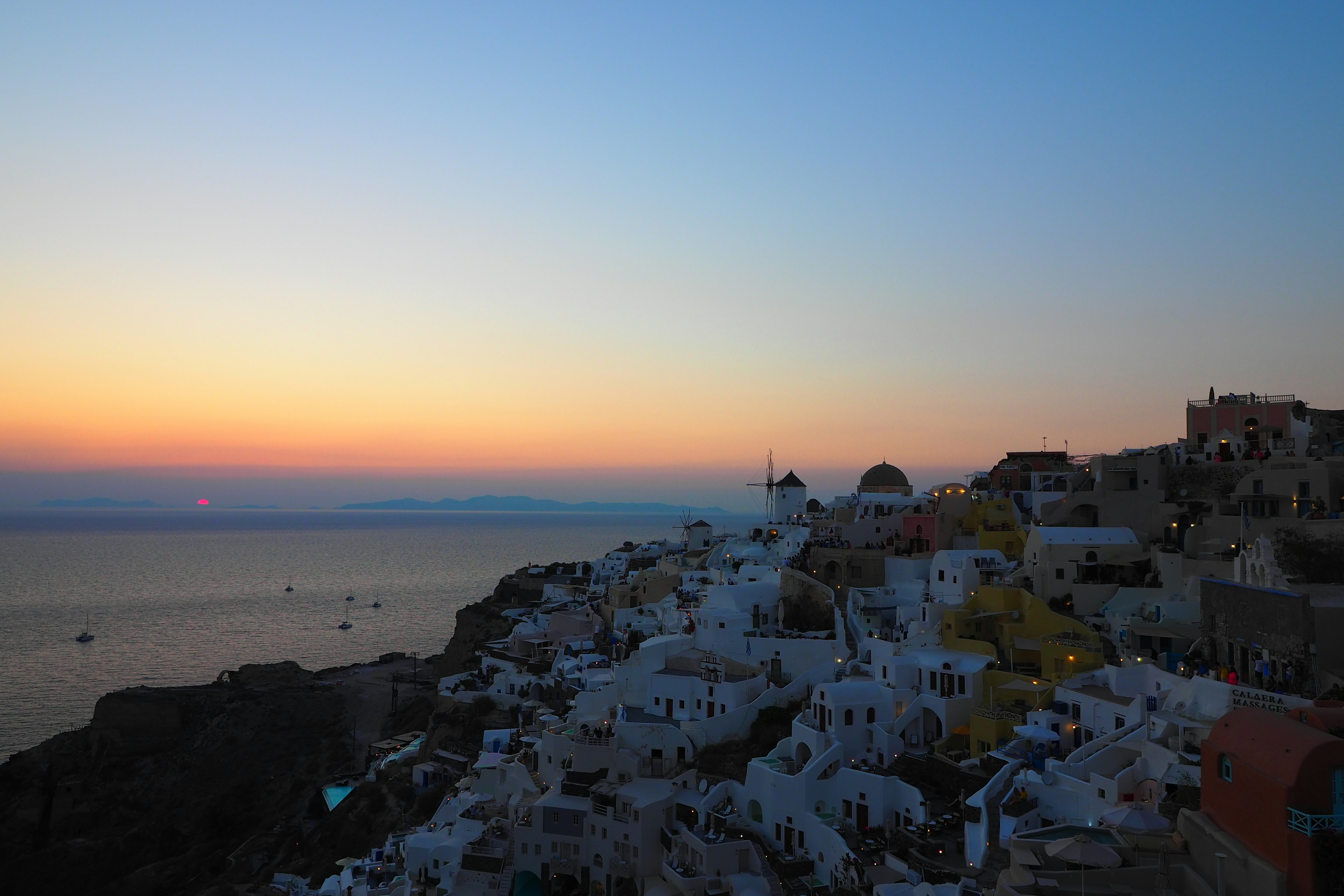 Costa di Santorini al tramonto con edifici bianchi