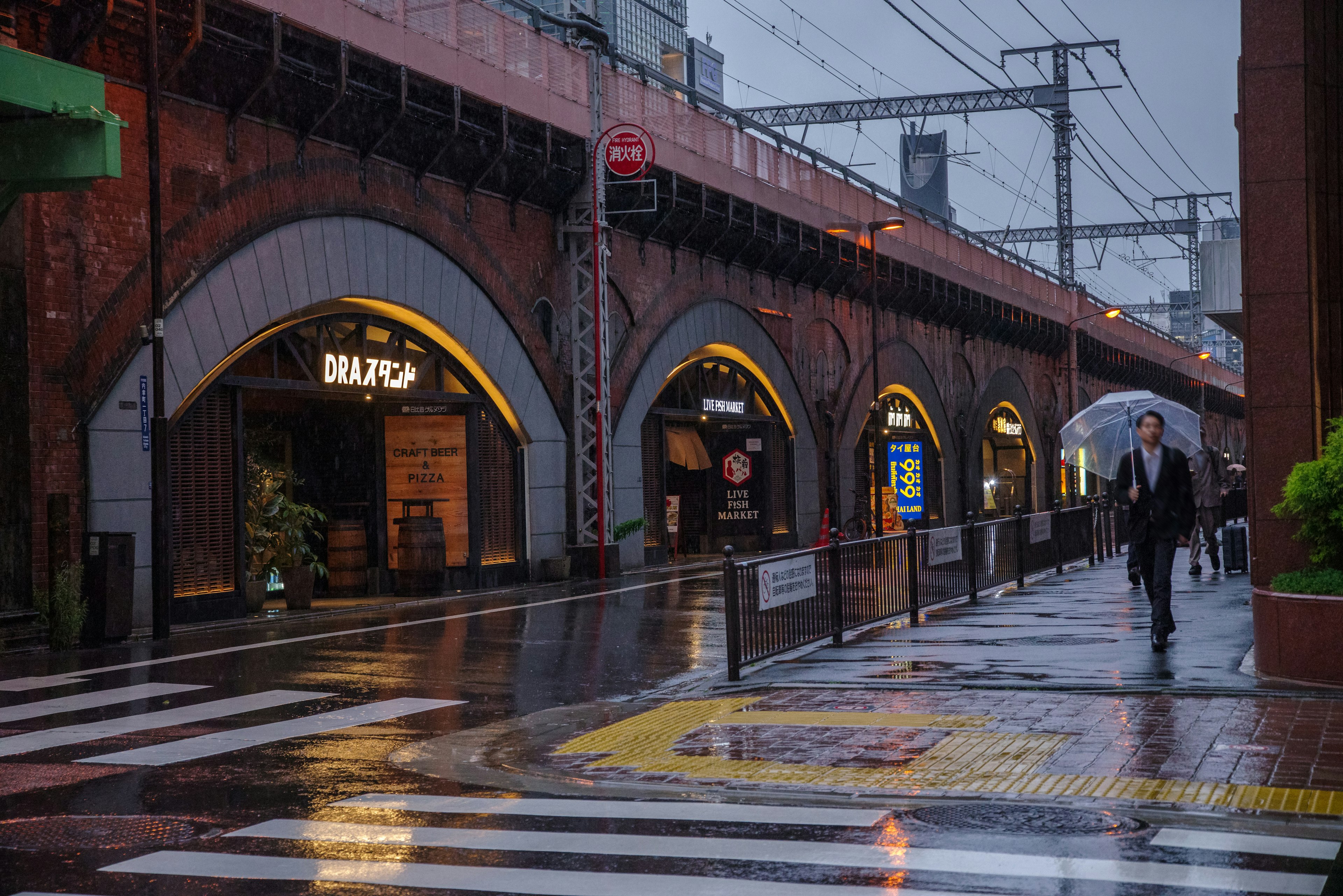 Strada della città con ponte ad arco sotto la pioggia