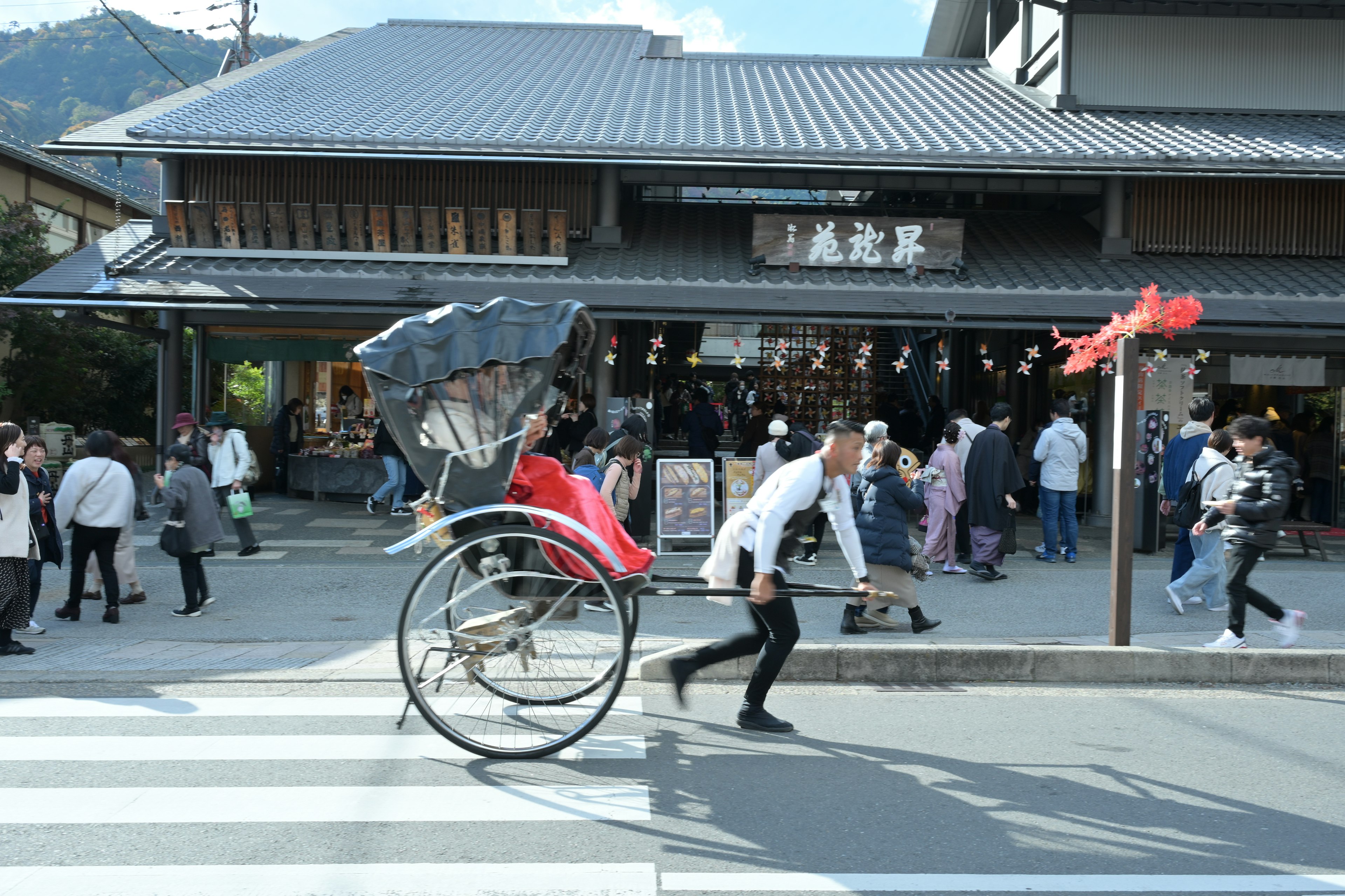 人力車を引く人物と賑やかな通りの風景