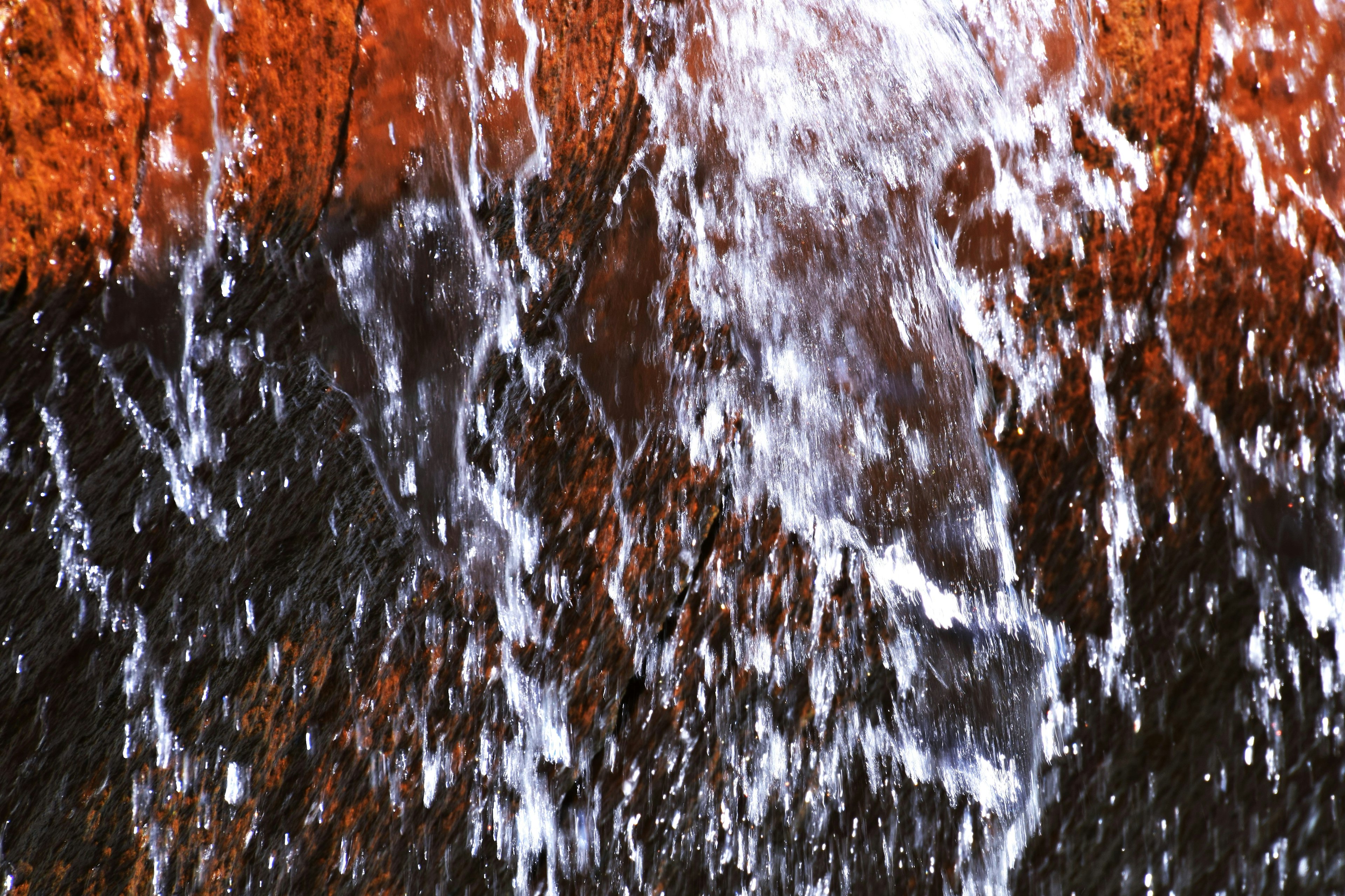 Agua fluyendo con un fondo de roca naranja