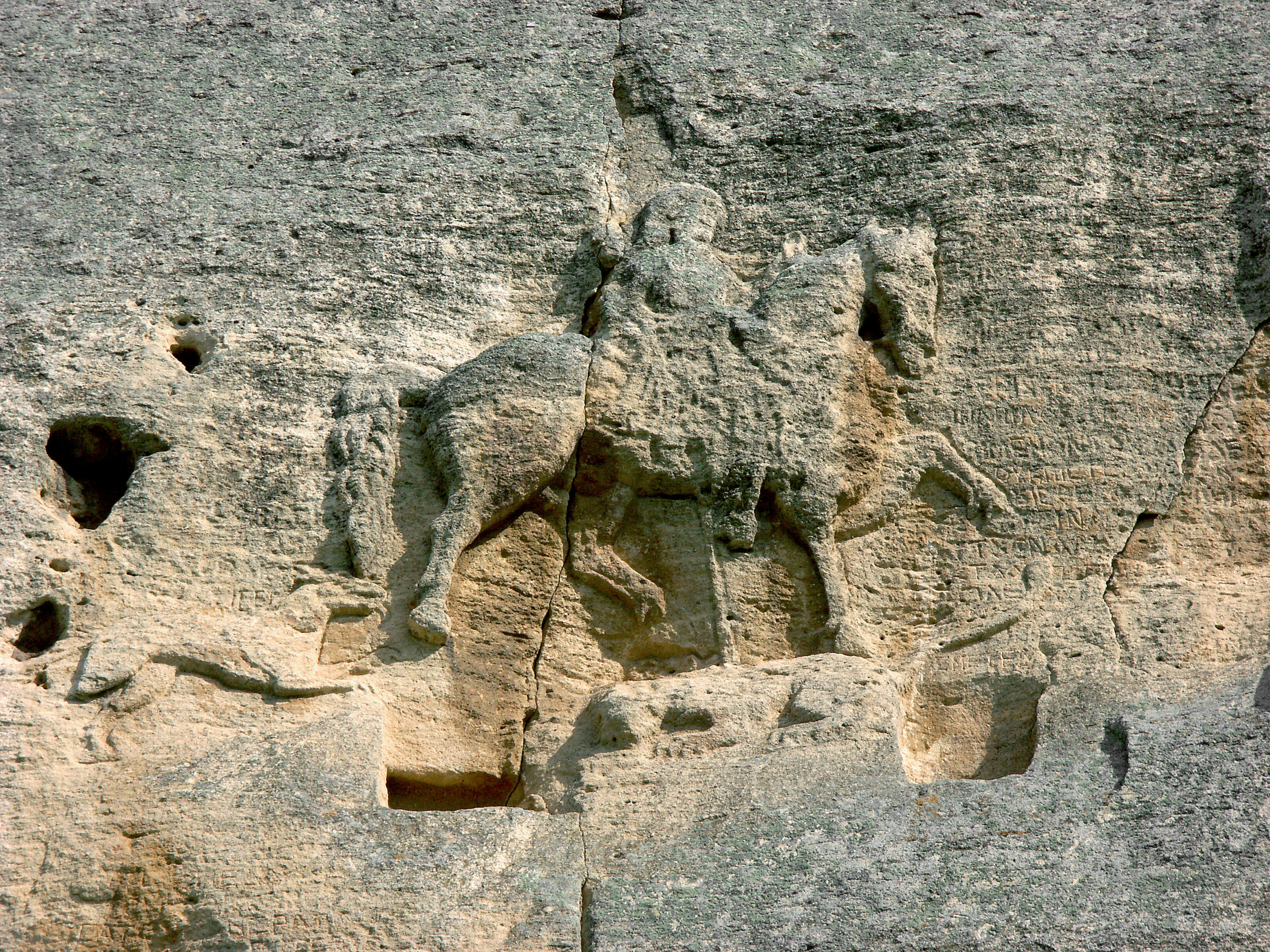 Detalle de una escultura de caballero en una pared de roca