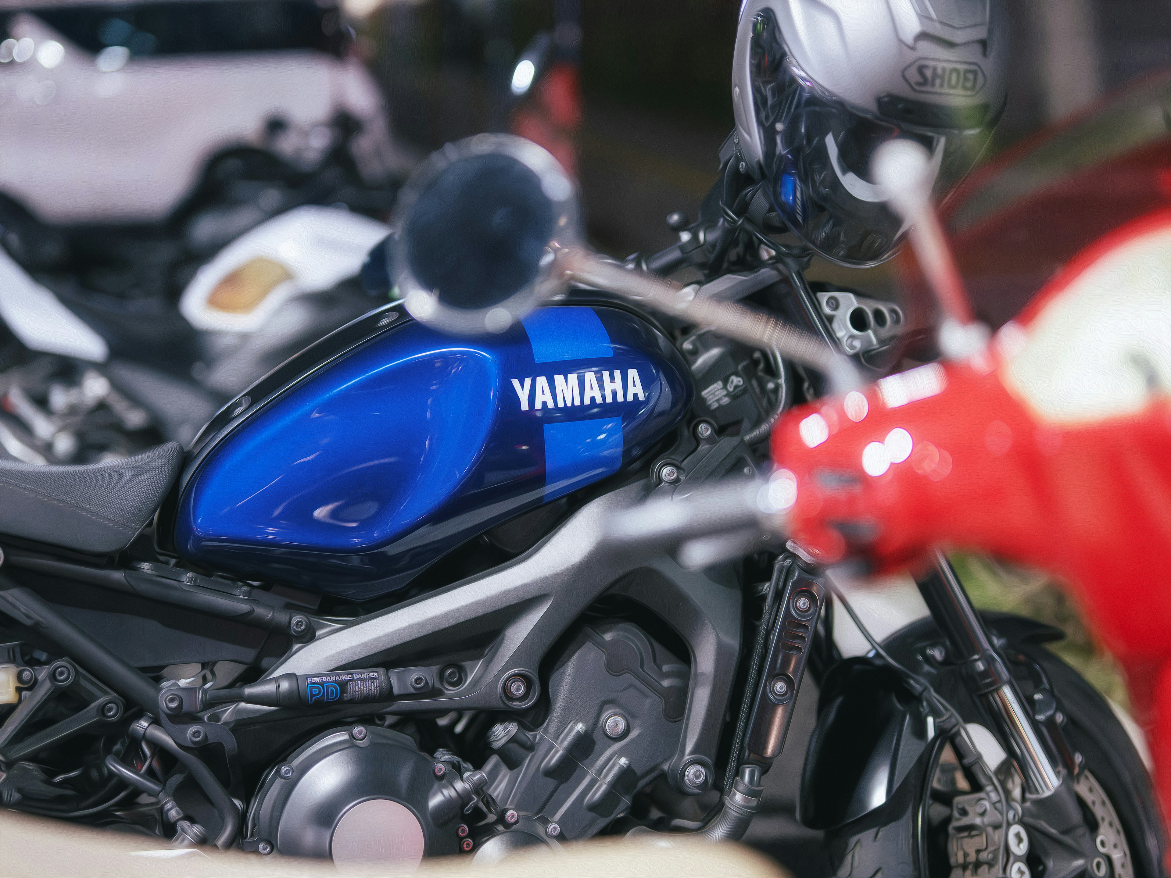 Motocicleta Yamaha azul estacionada con otras motos de fondo