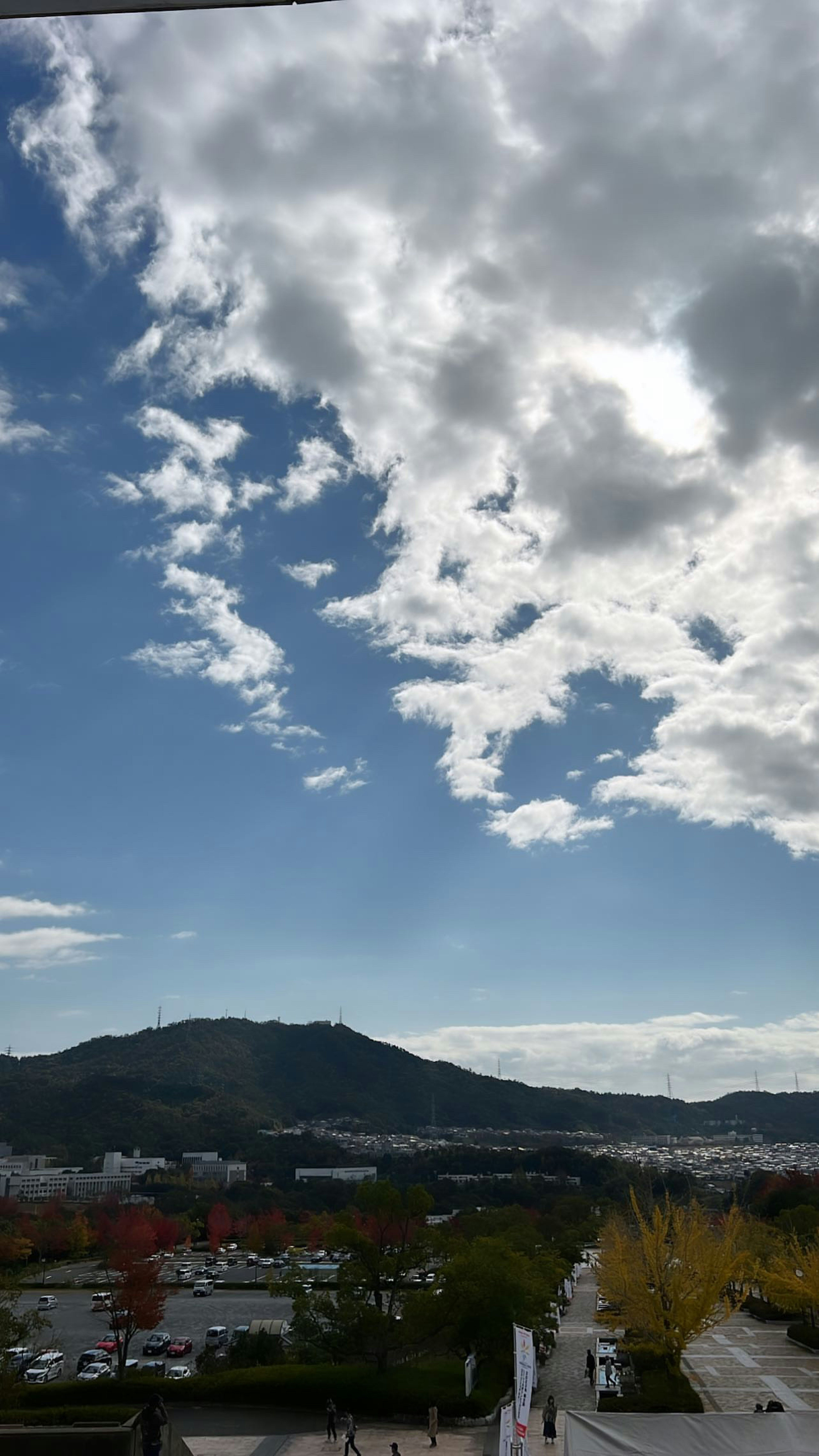 Scenic view of blue sky with white clouds mountains and cityscape