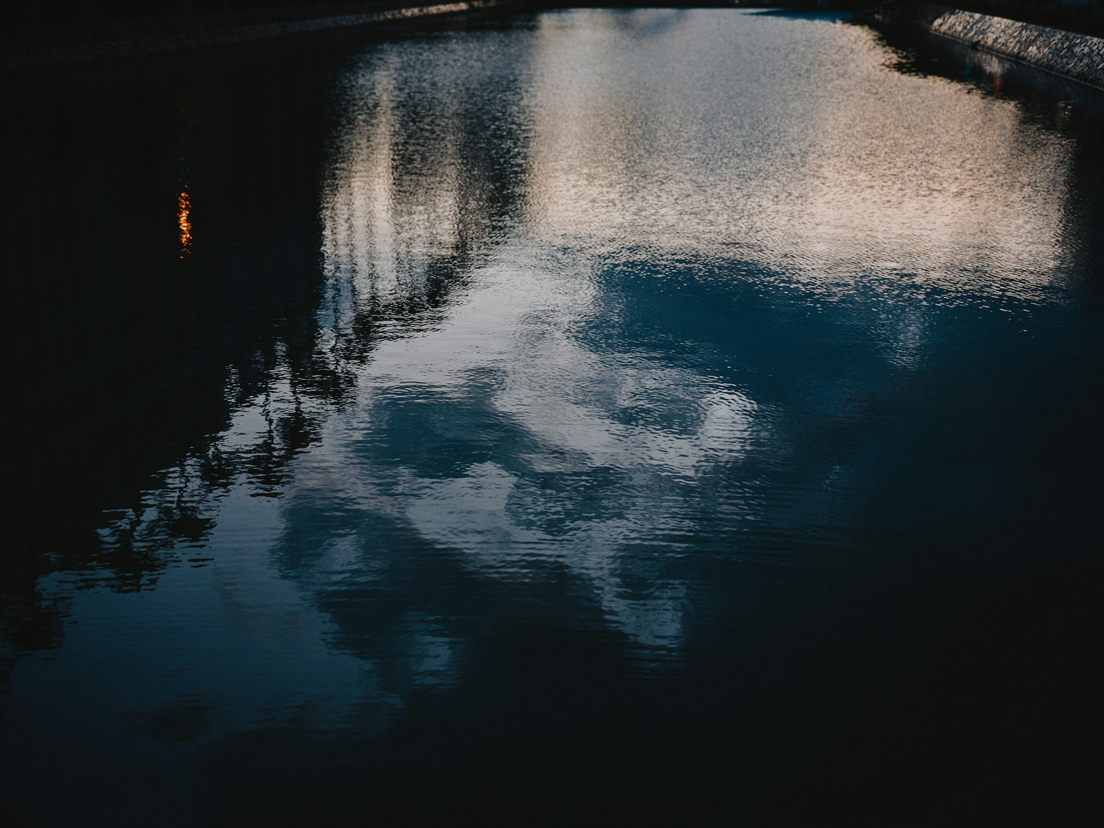 Reflection of clouds and surrounding scenery on water surface