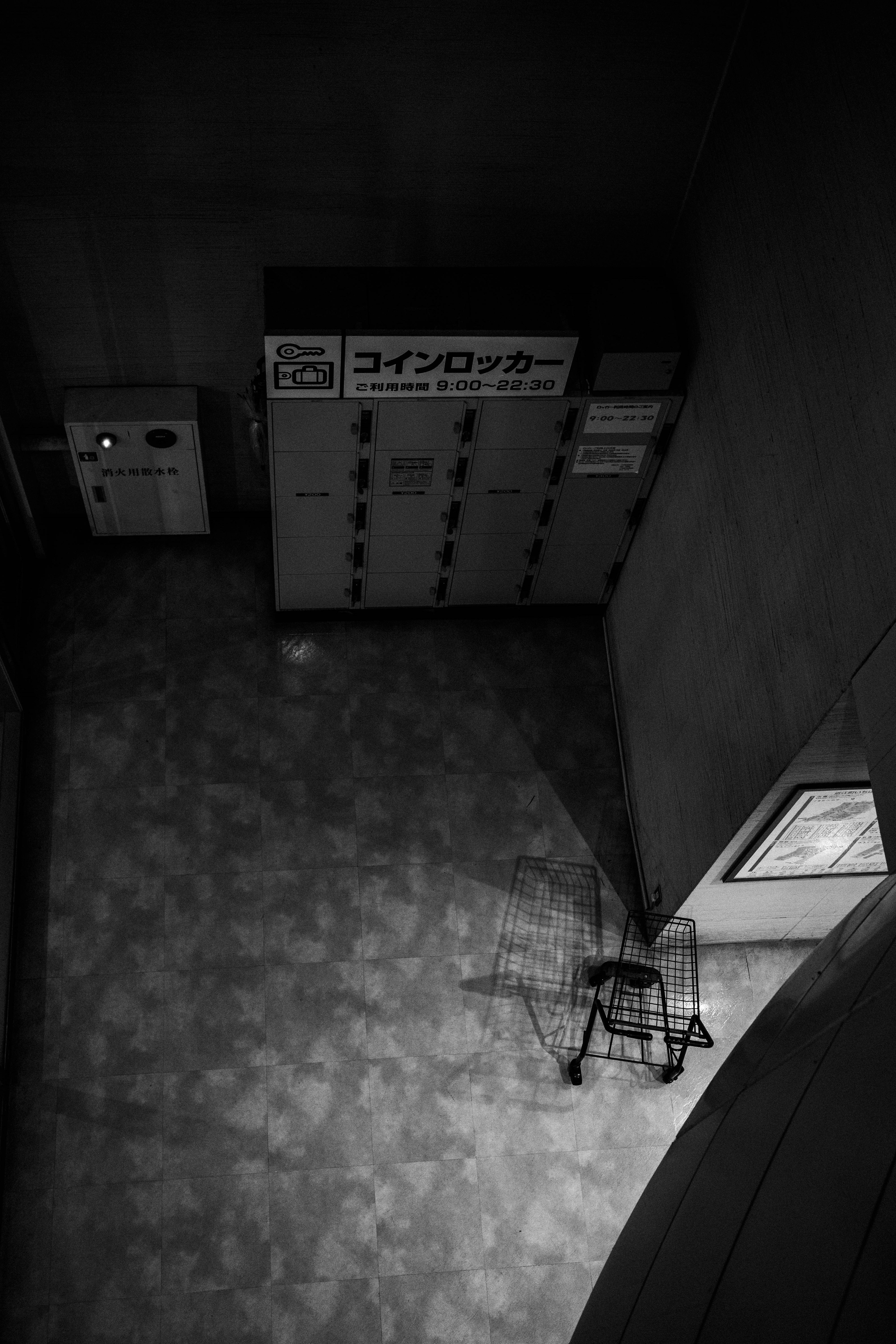 Shadow of a cart in a dimly lit space with lockers