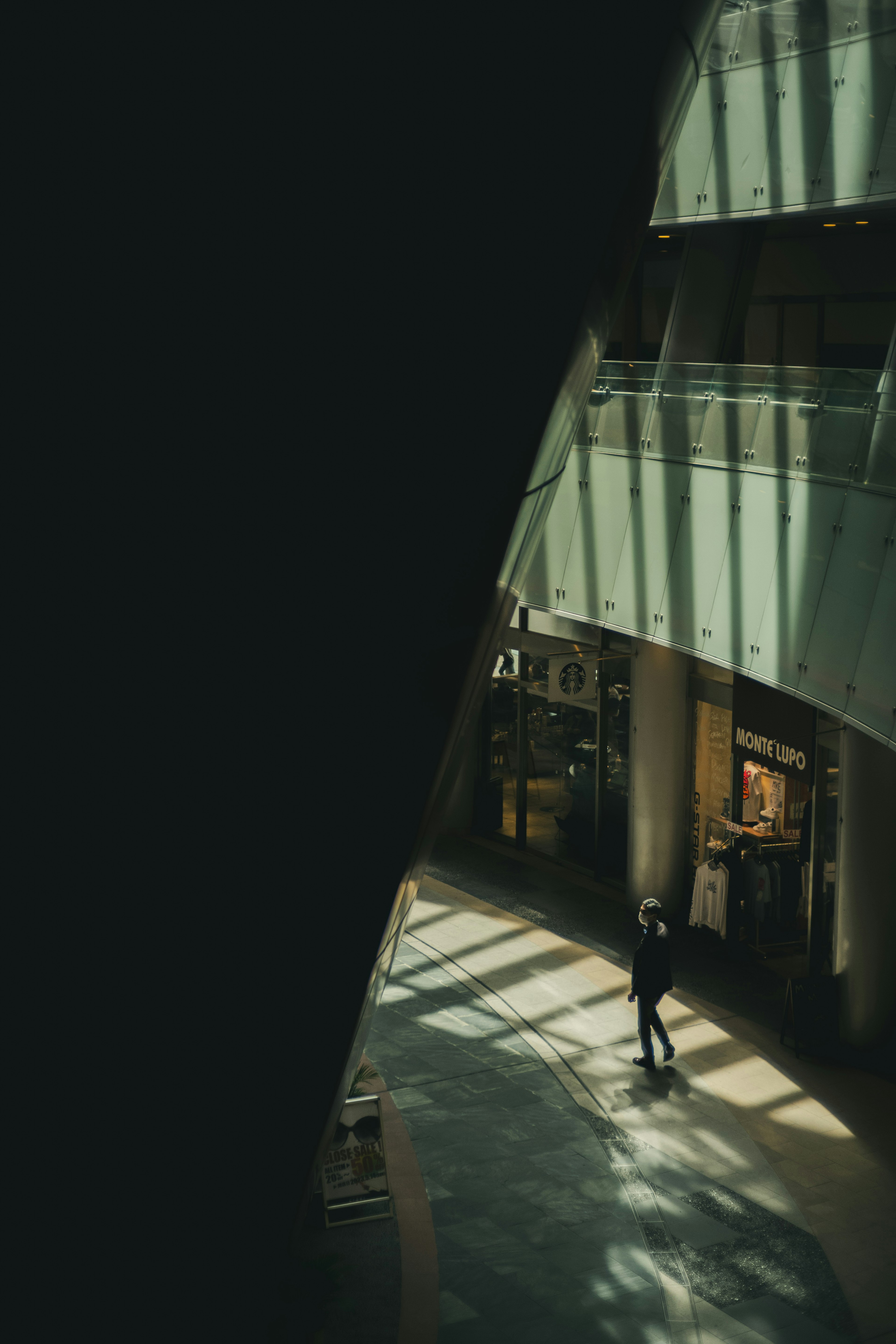 Une personne debout dans un espace faiblement éclairé avec de la lumière traversant l'intérieur du bâtiment