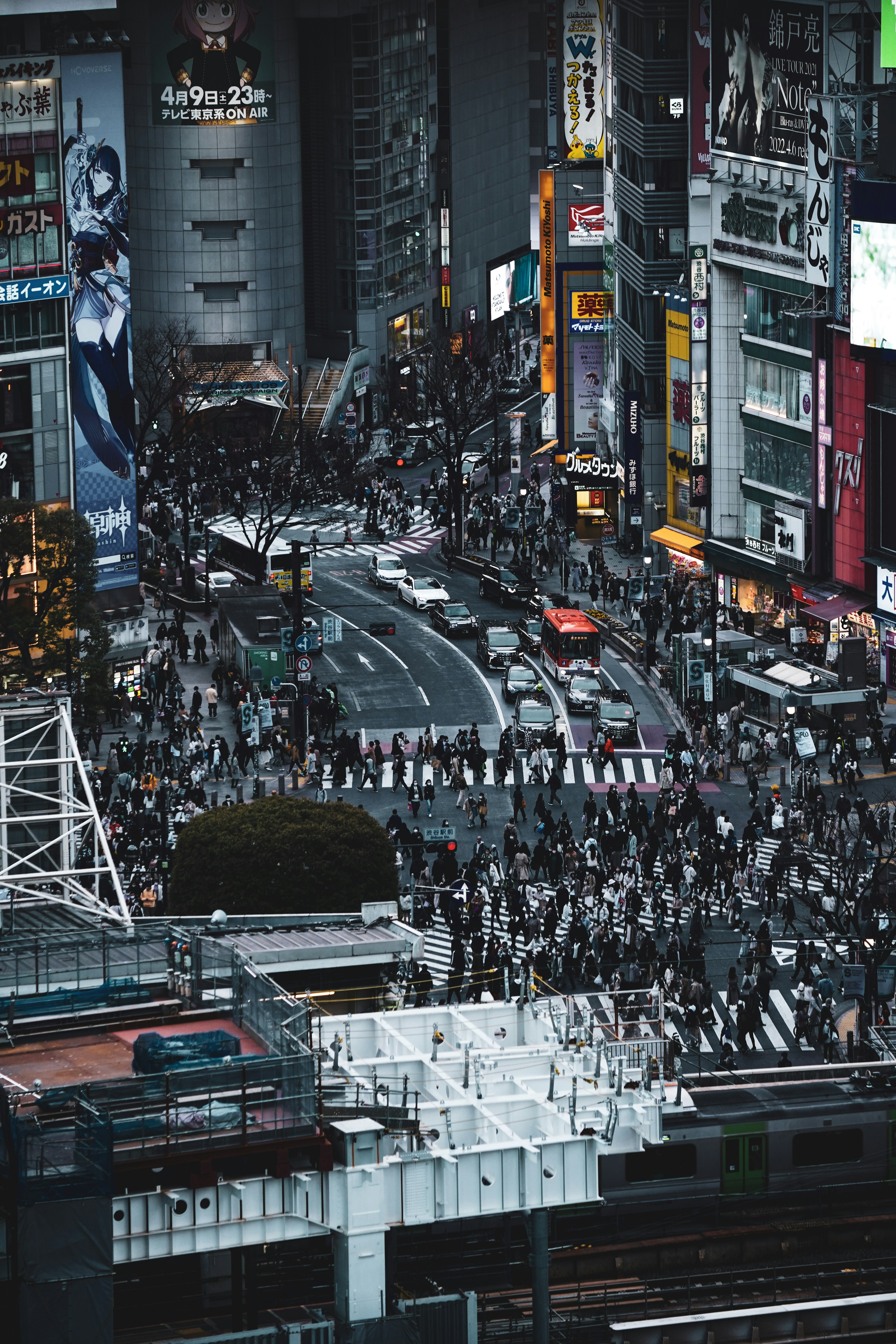 Una escena de calle bulliciosa en Shibuya con multitudes y letreros de neón de noche