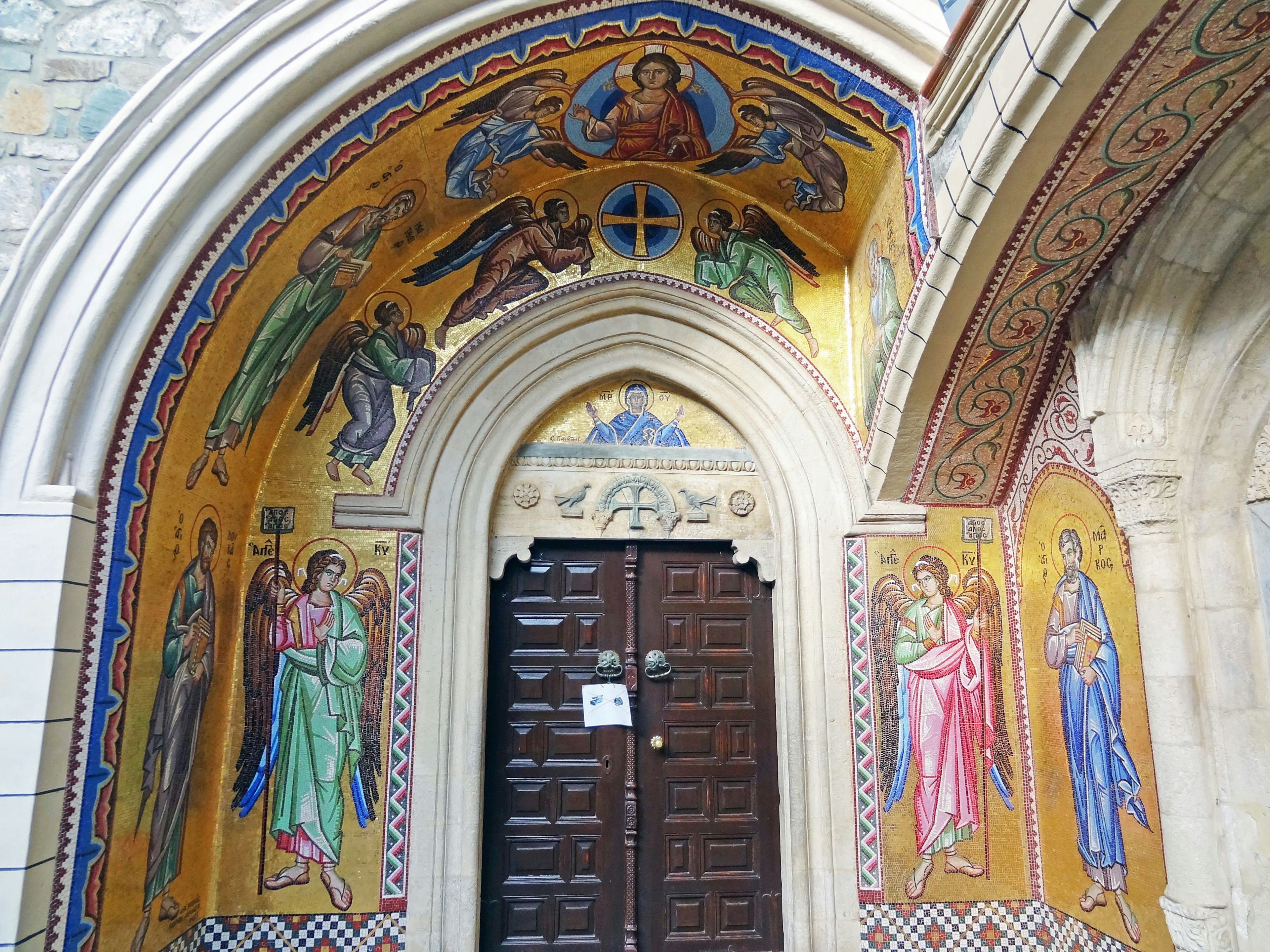 Lengkungan pintu masuk gereja yang dihiasi dengan fresco yang hidup