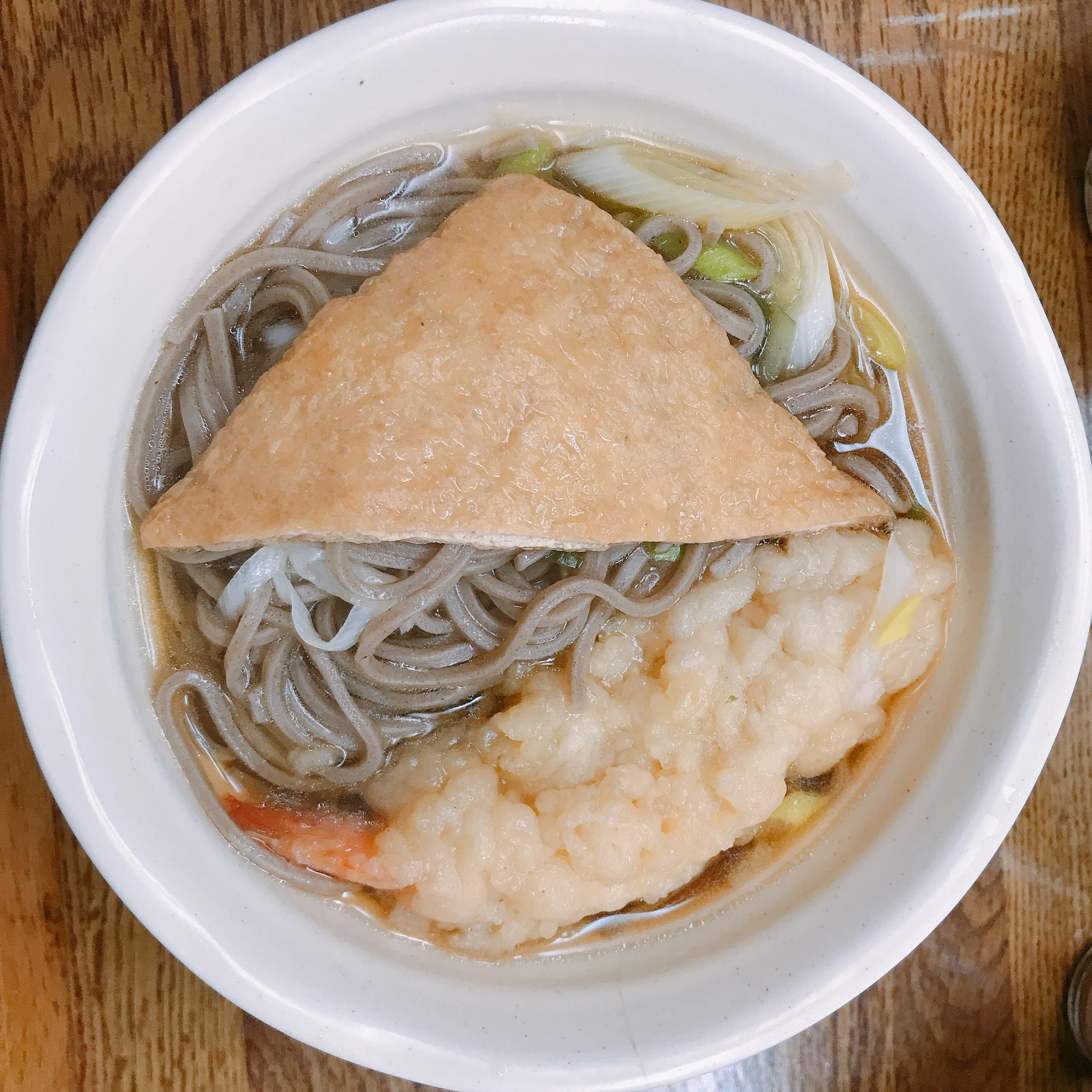 Bowl of soba noodles with tempura shrimp and triangular fried tofu