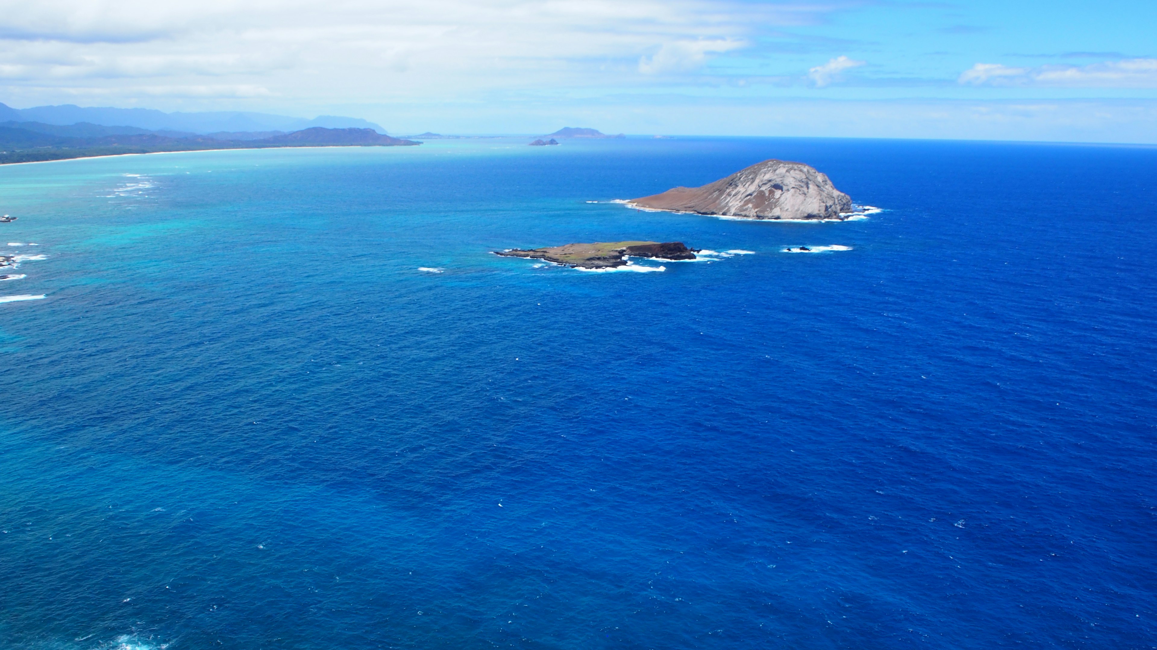 Aerial view of a vibrant blue ocean with small islands