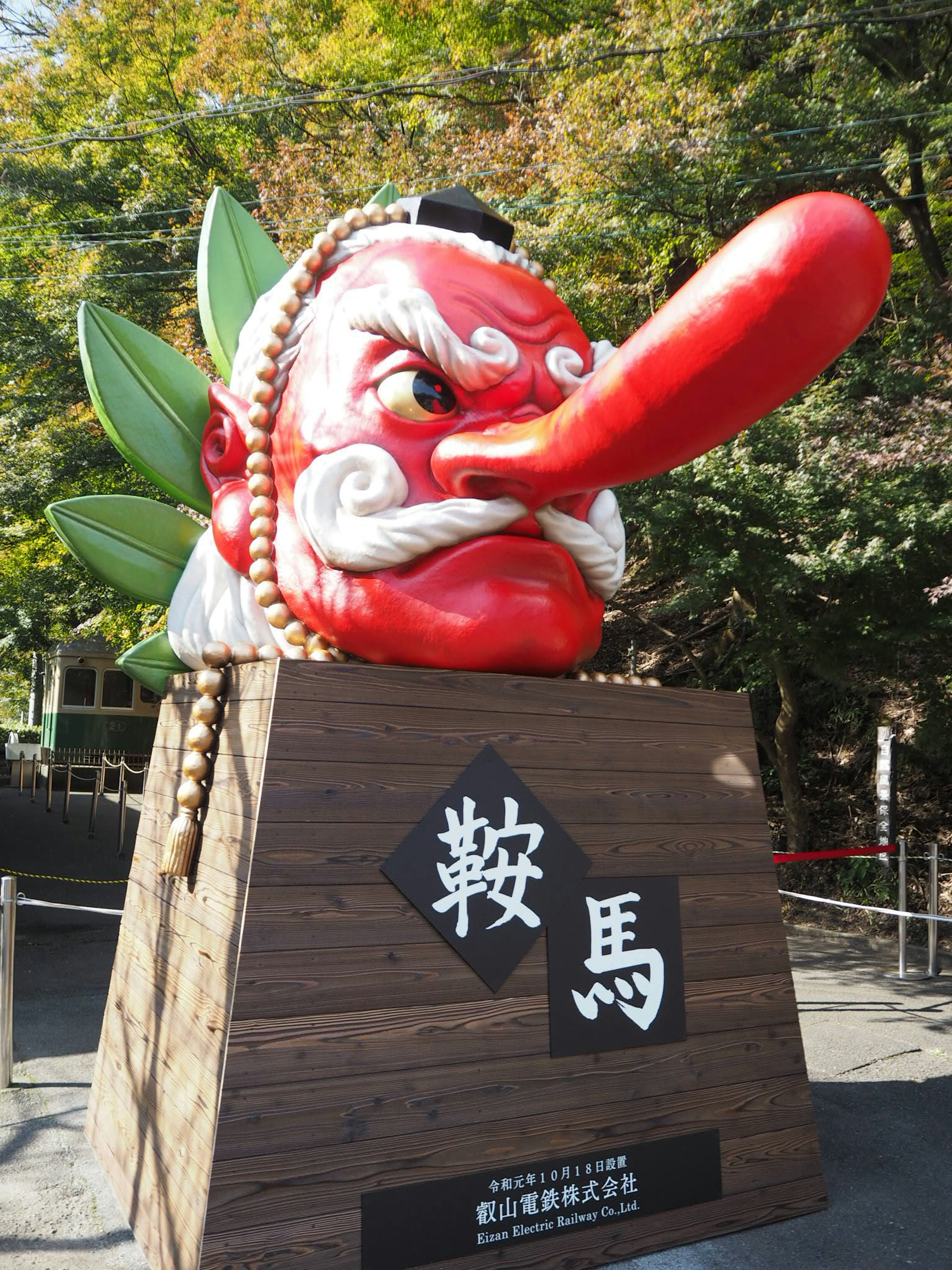 Grande statue au visage rouge avec un nez proéminent représentant une décoration de festival