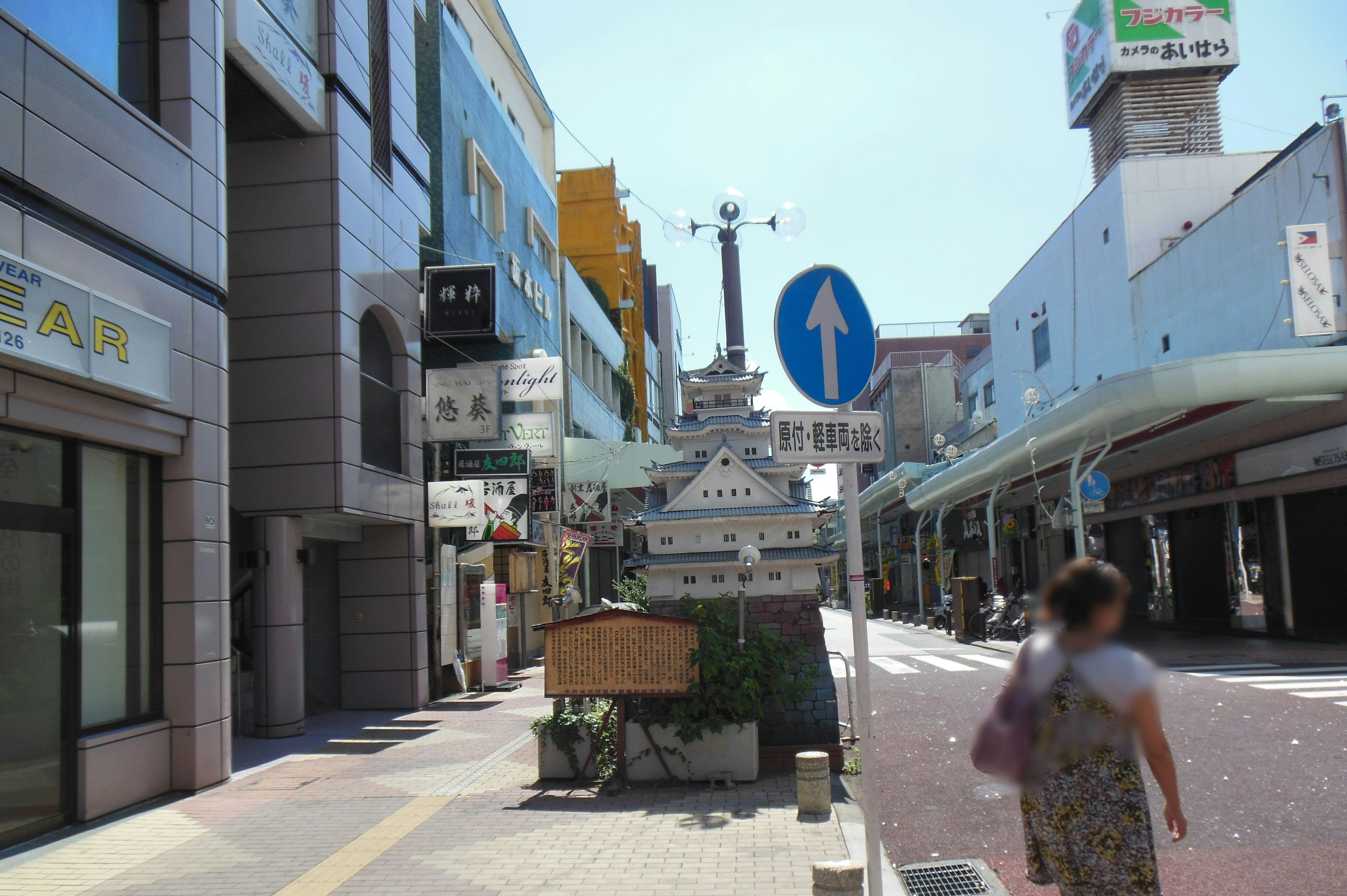 繁忙街道場景，商店在藍天下