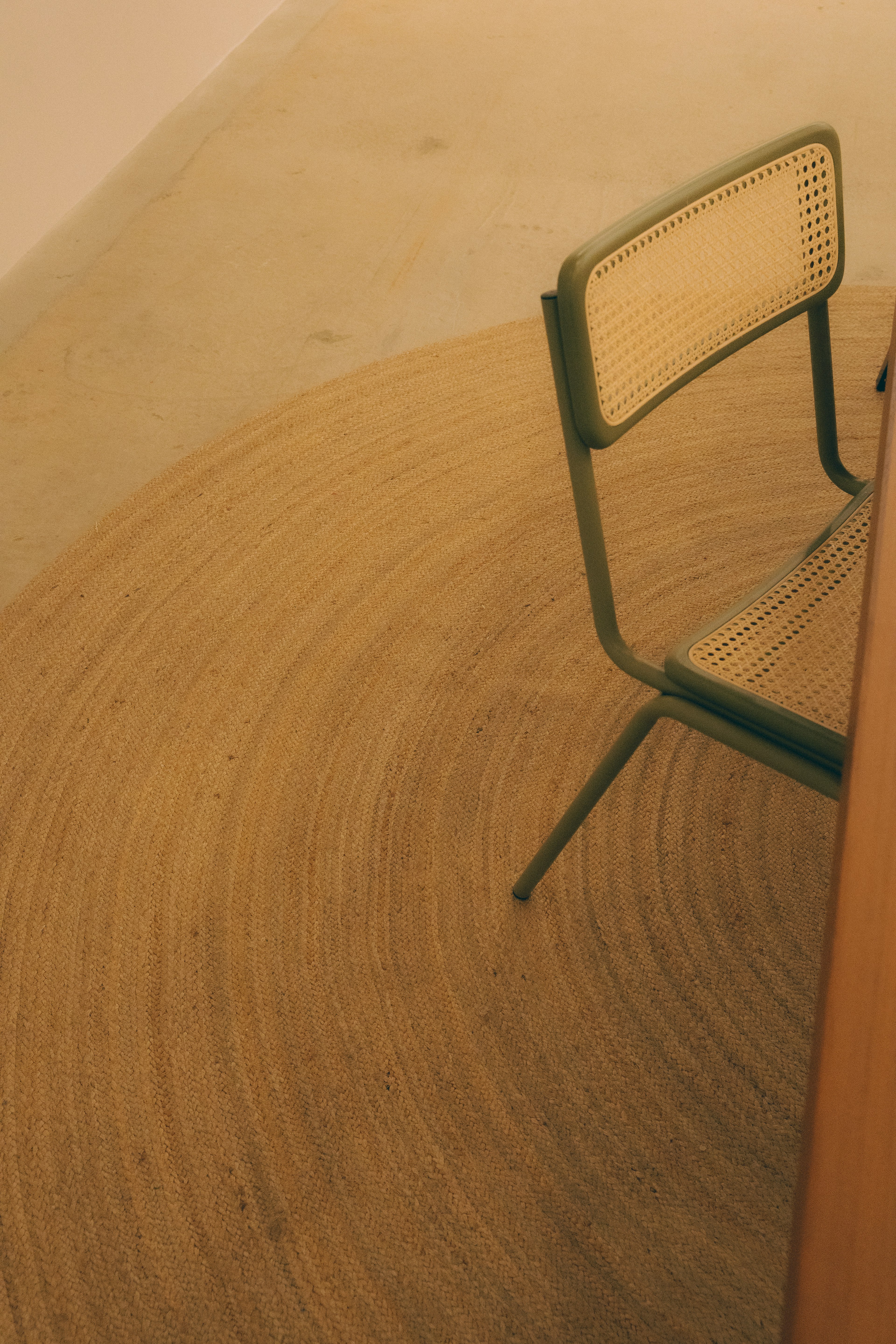 Green chair next to a wooden table in a simple interior