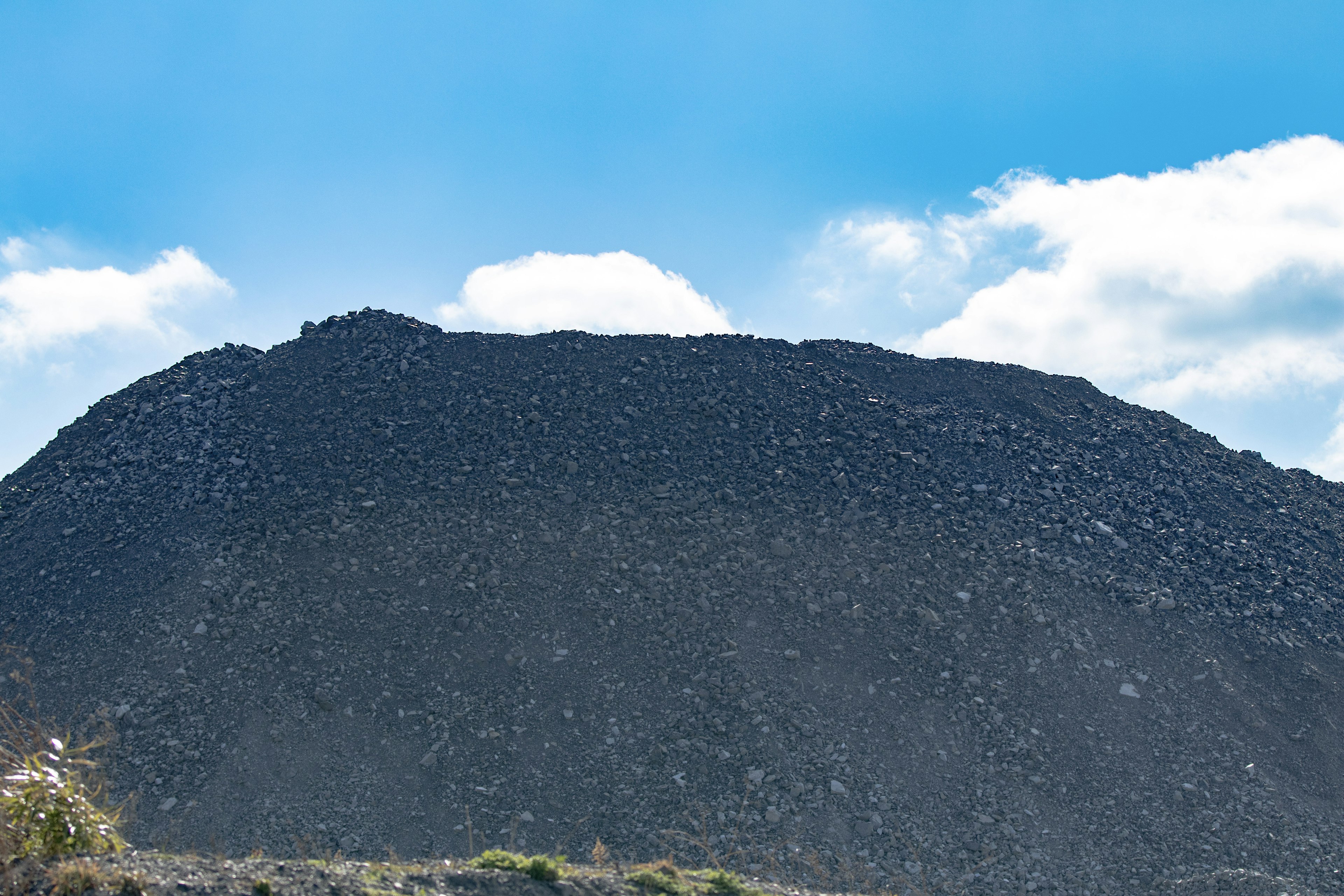 Un paisaje de montaña negra bajo un cielo azul