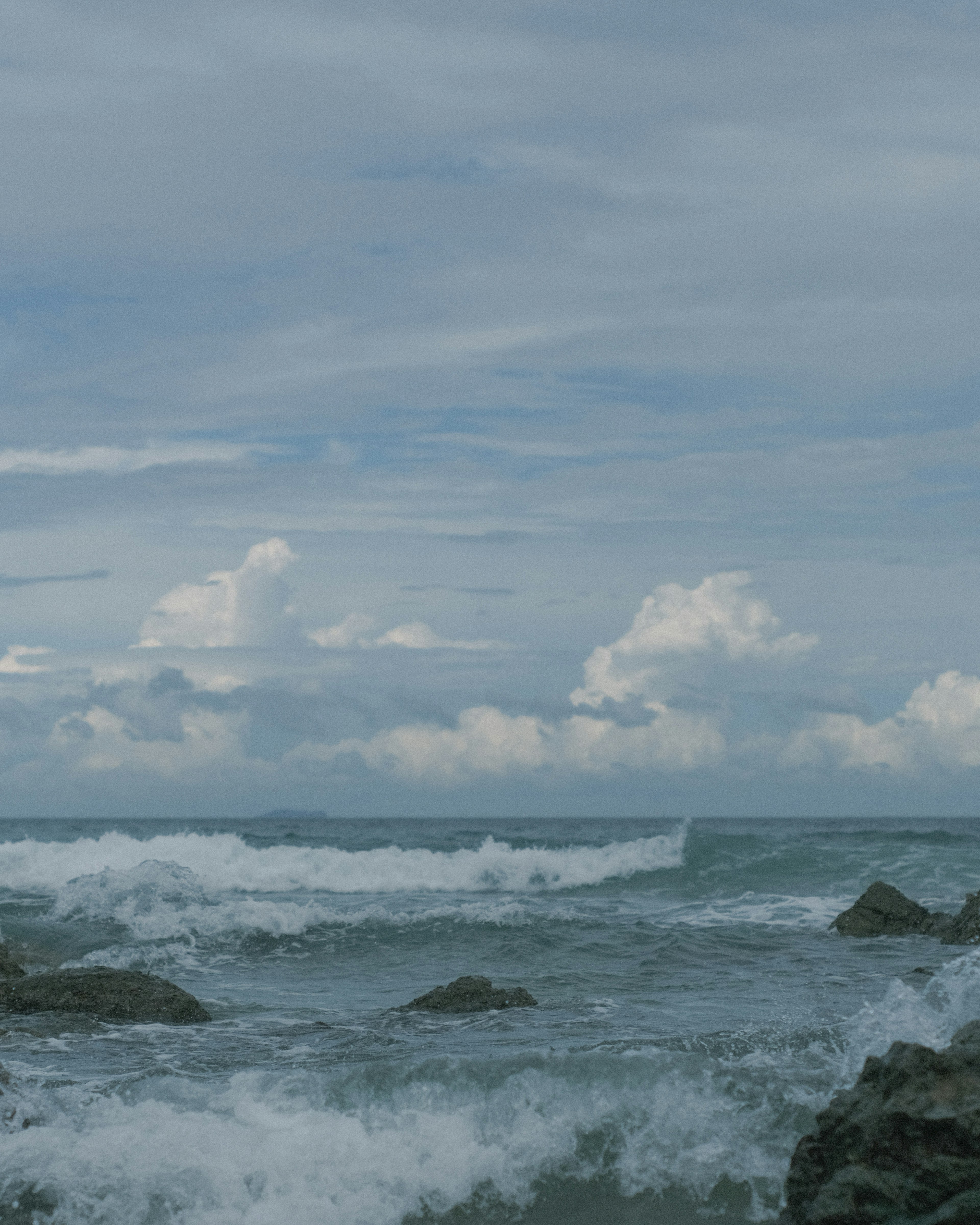 海の波と雲のある青い空の風景