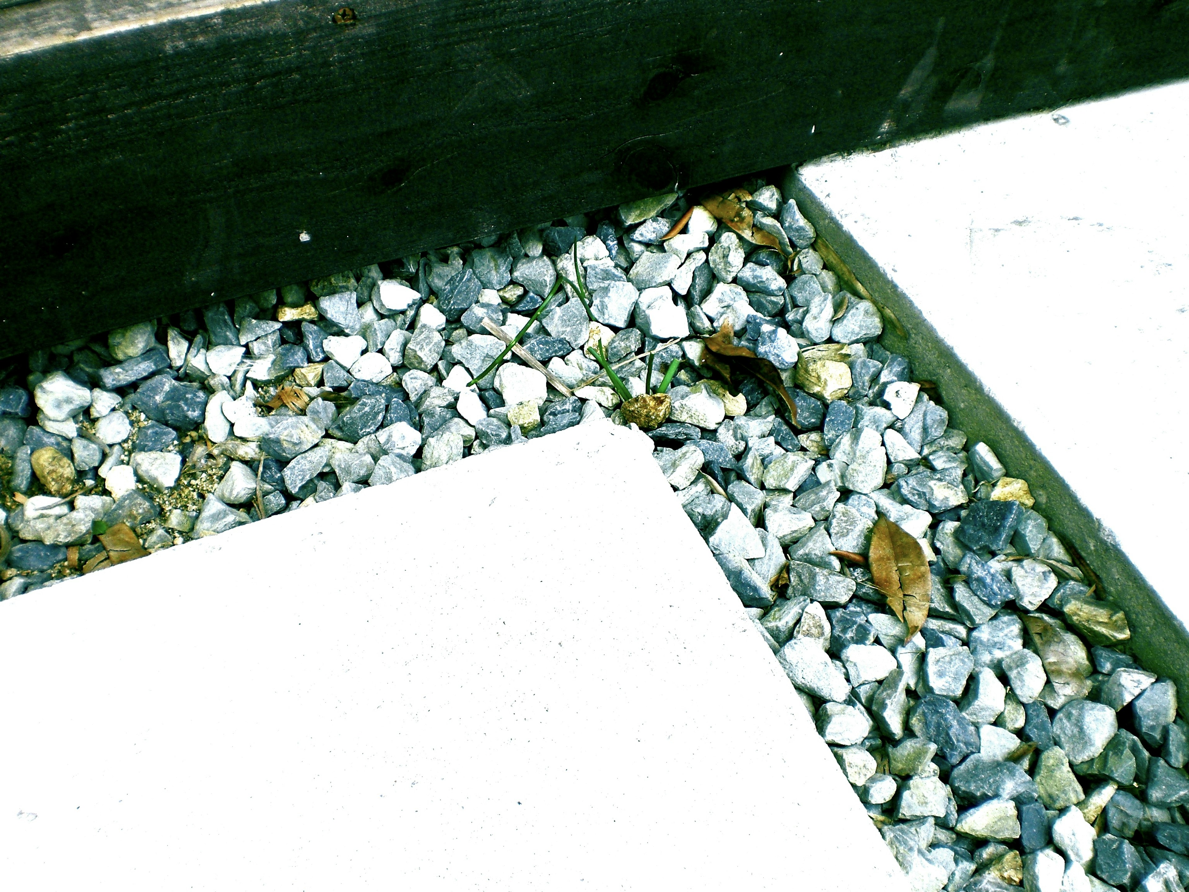 Esquina de un jardín con piedras blancas y grava