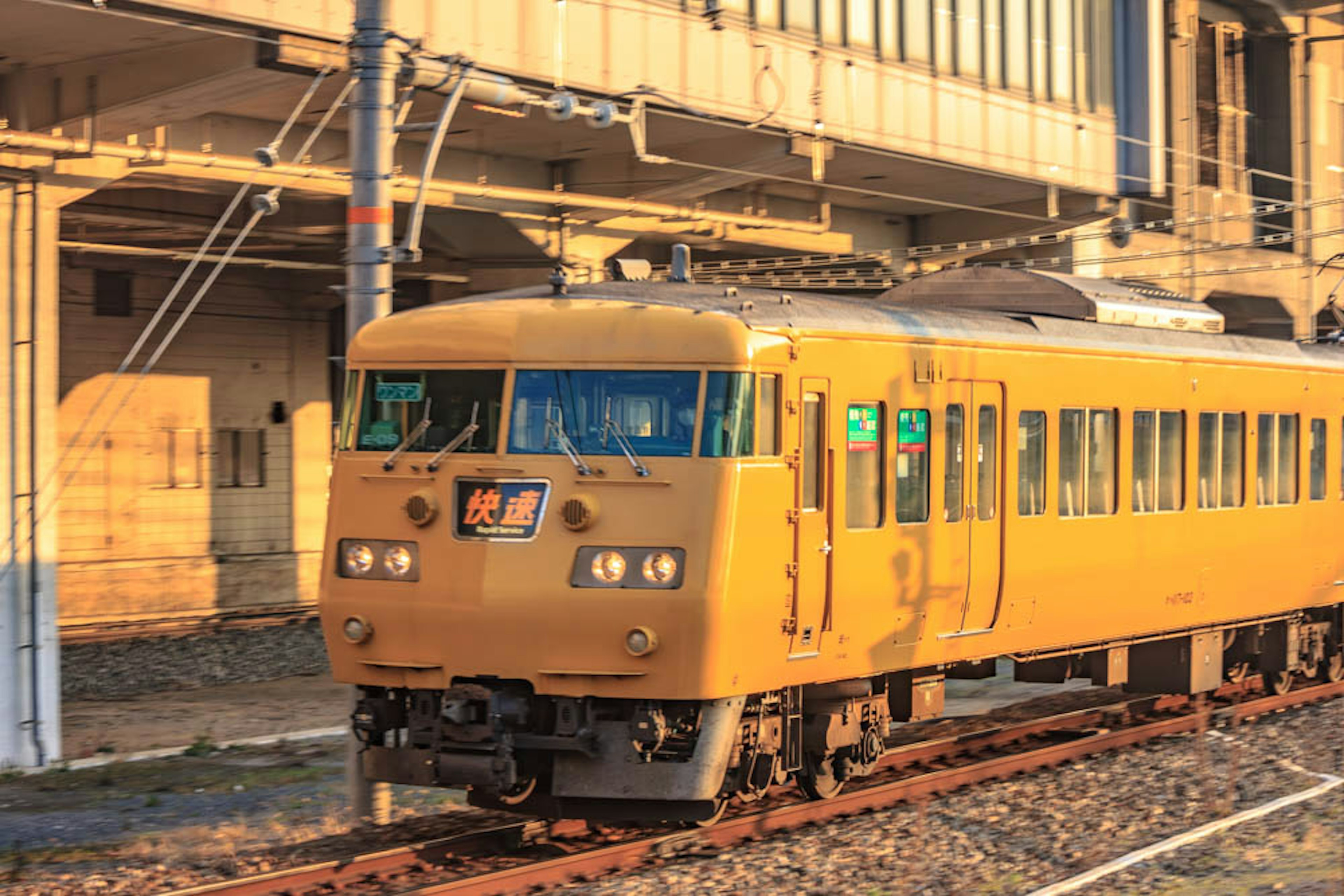 黄色い列車が駅に停車している夕暮れの風景