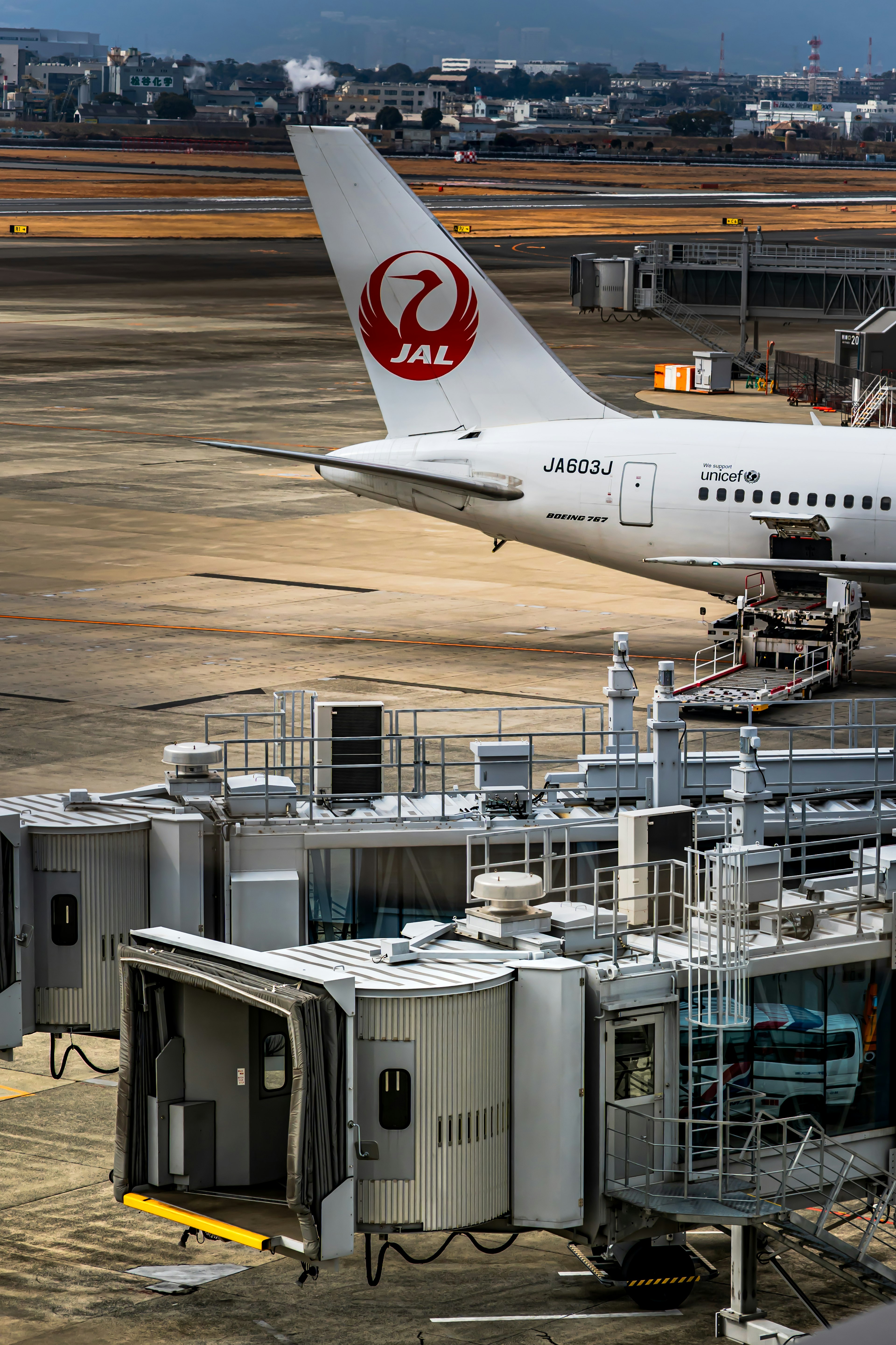 Máy bay Japan Airlines tại sân bay với cổng lên máy bay