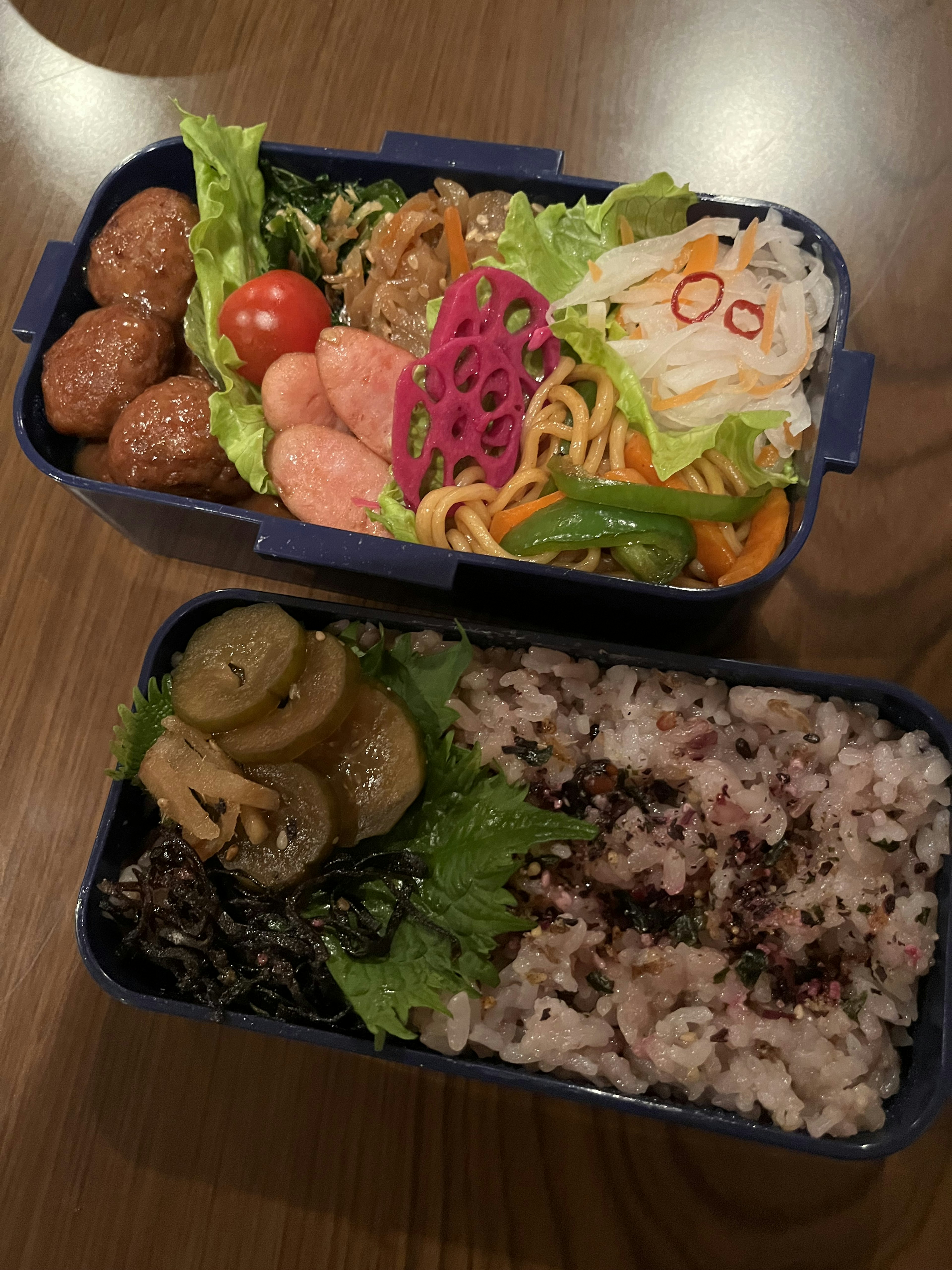 Kotak bento berwarna-warni dengan berbagai bahan Bakso dan salad sayuran dalam wadah dua tingkat Makanan berbentuk bunga sebagai sorotan