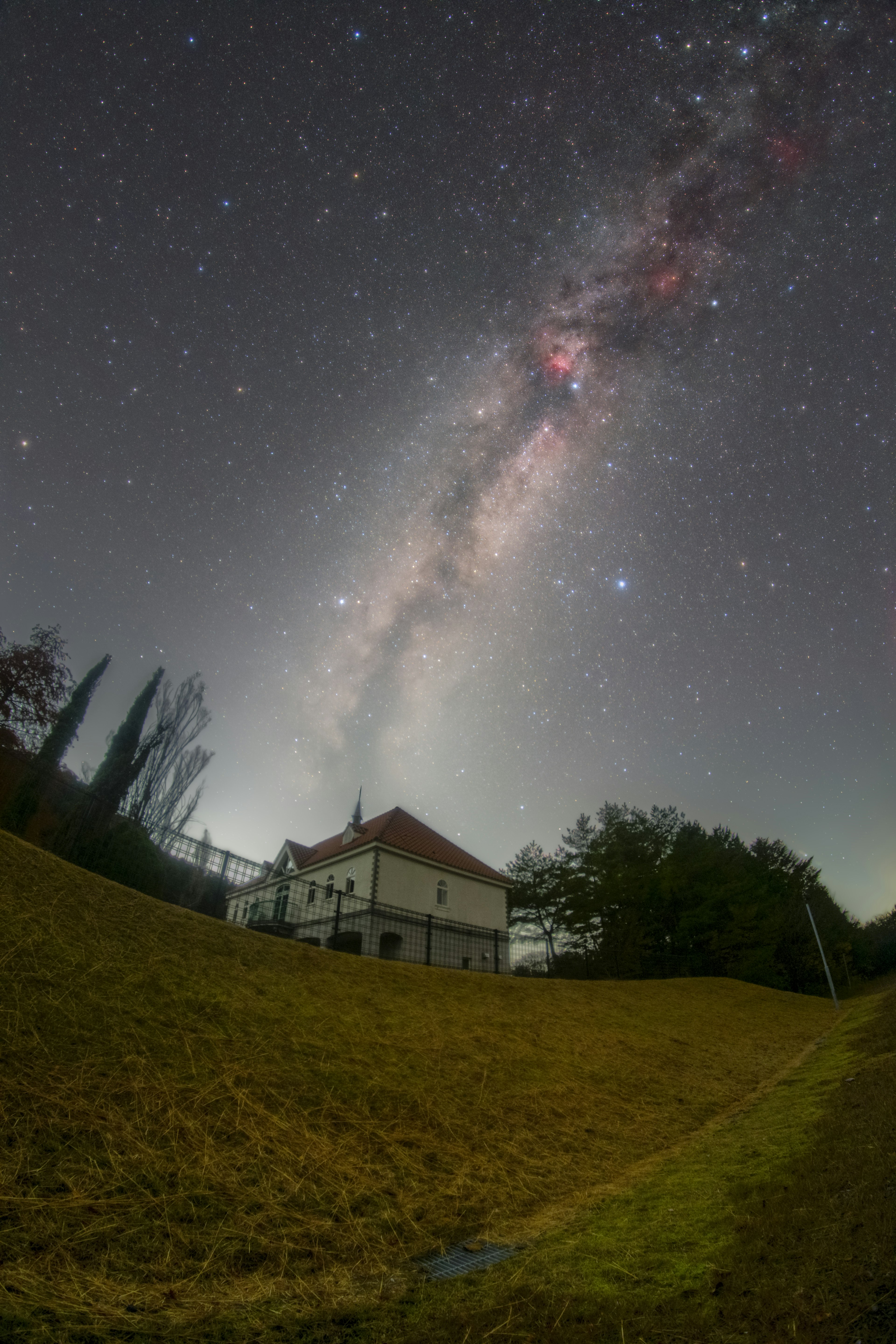 星空の下にある白い家と草原の風景