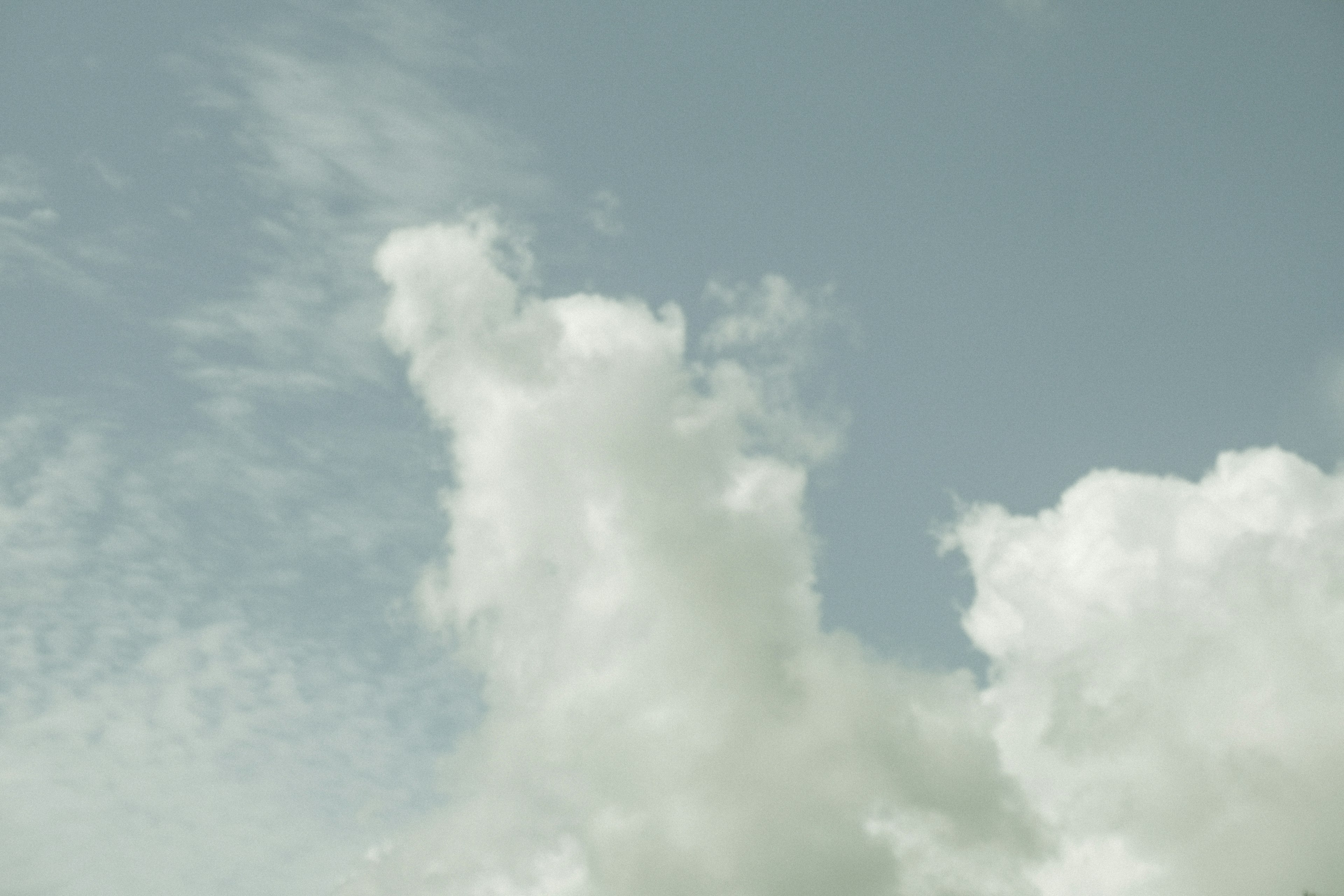 Weiße Wolken, die in einem blauen Himmel mit dünnen Wolken treiben