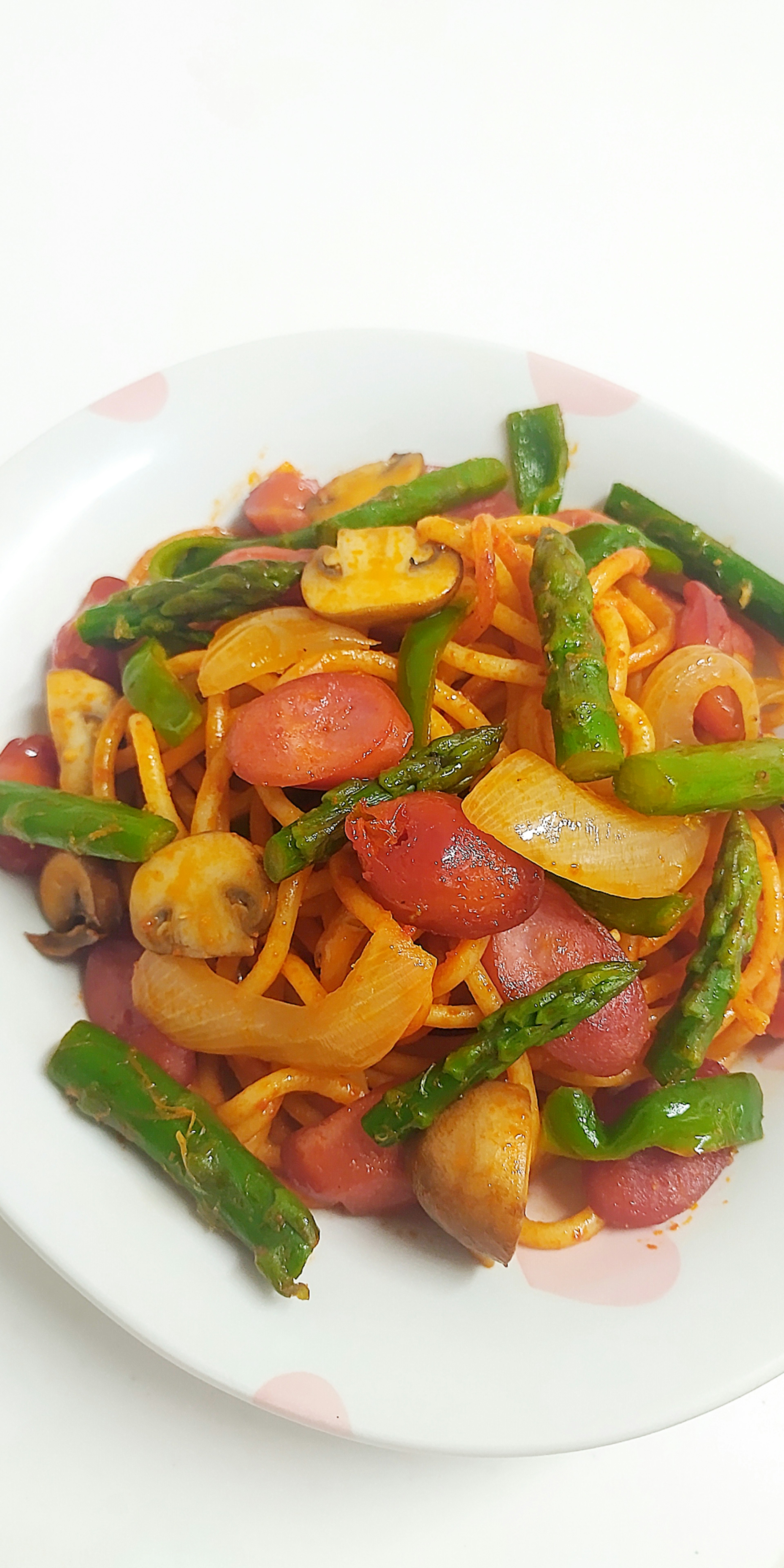 Stir-fried spaghetti with colorful vegetables served on a white plate