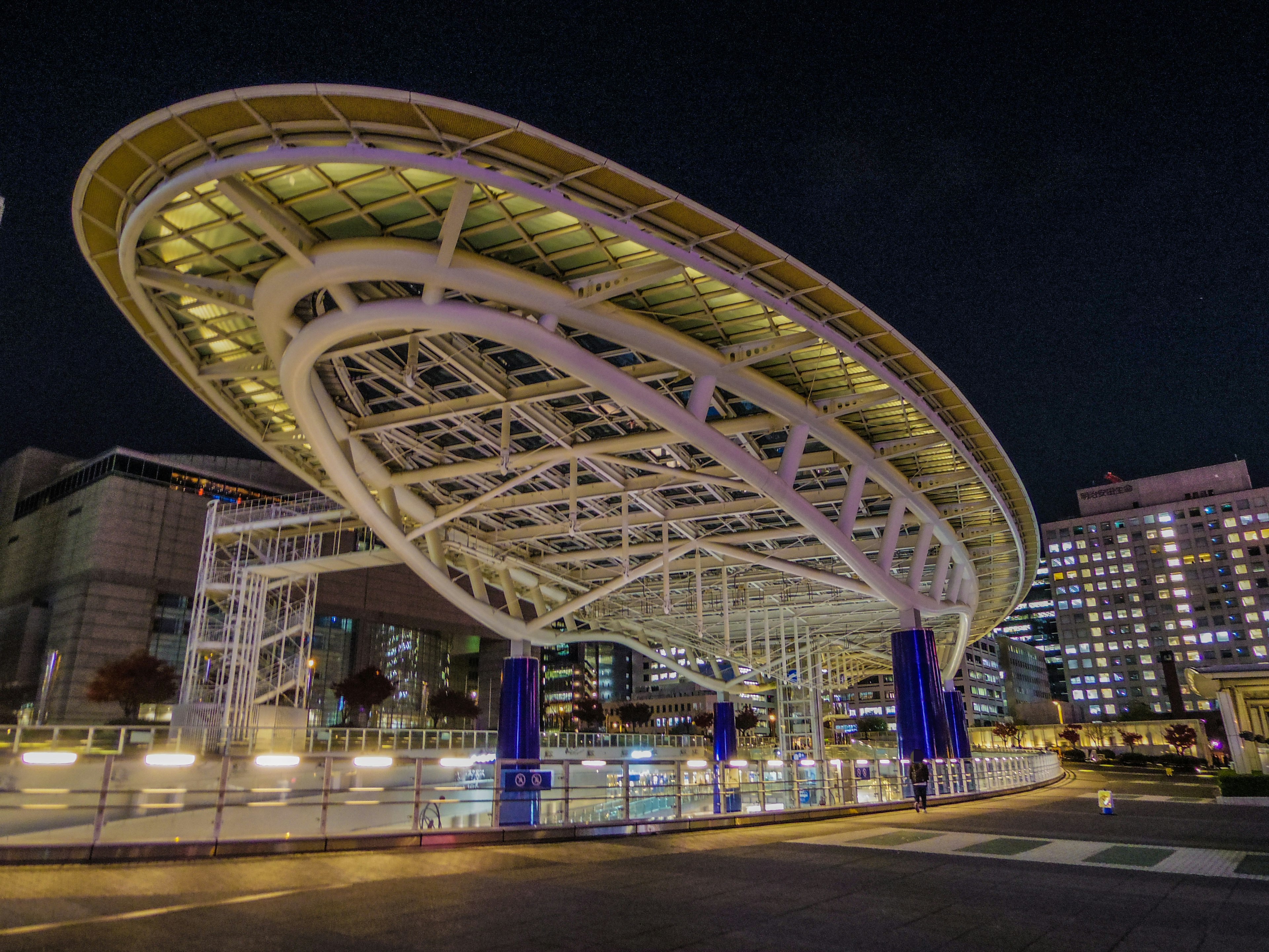 Modern roof structure illuminated at night in an urban setting