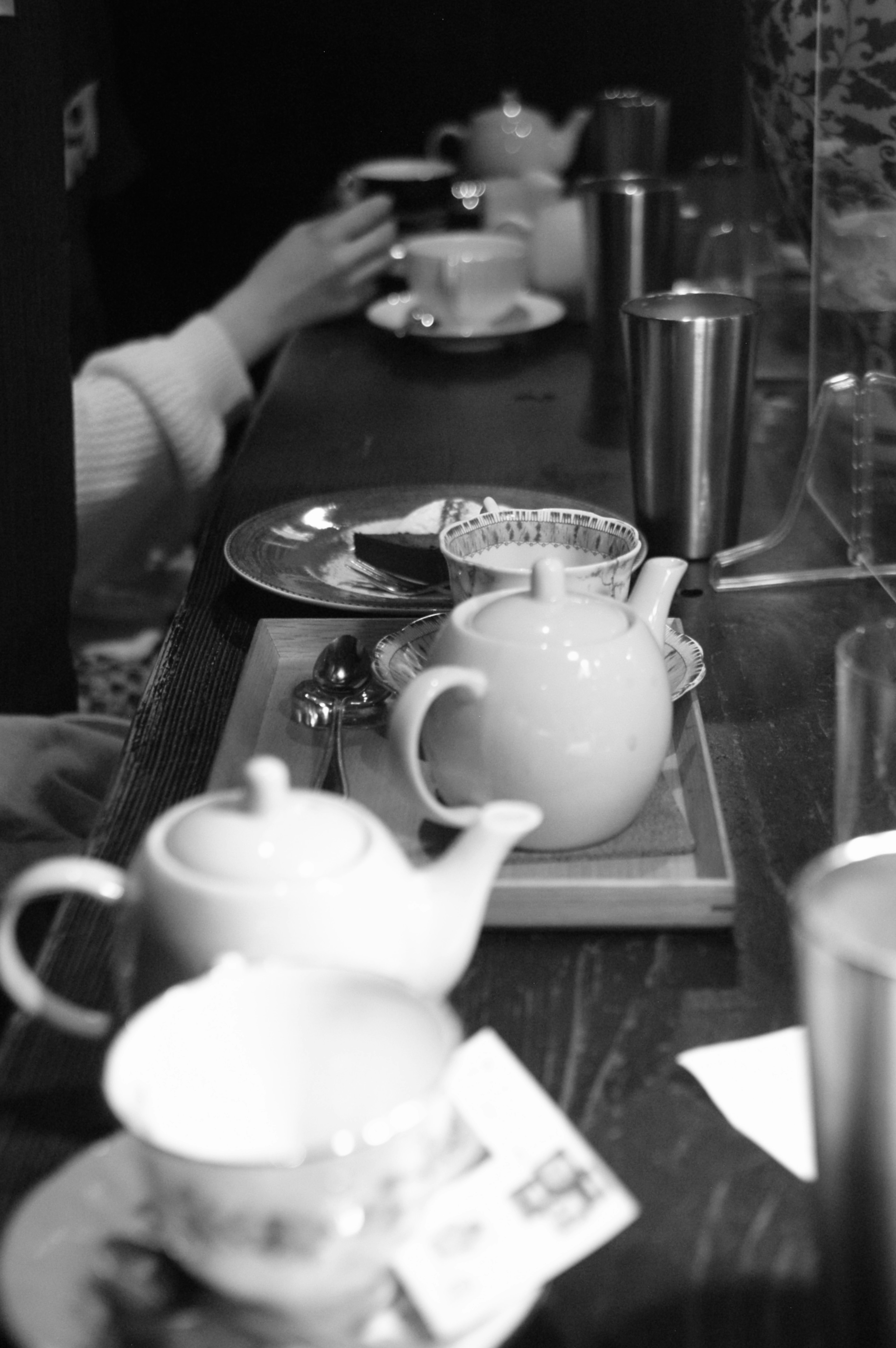 Foto en blanco y negro de teteras y tazas dispuestas en una mesa