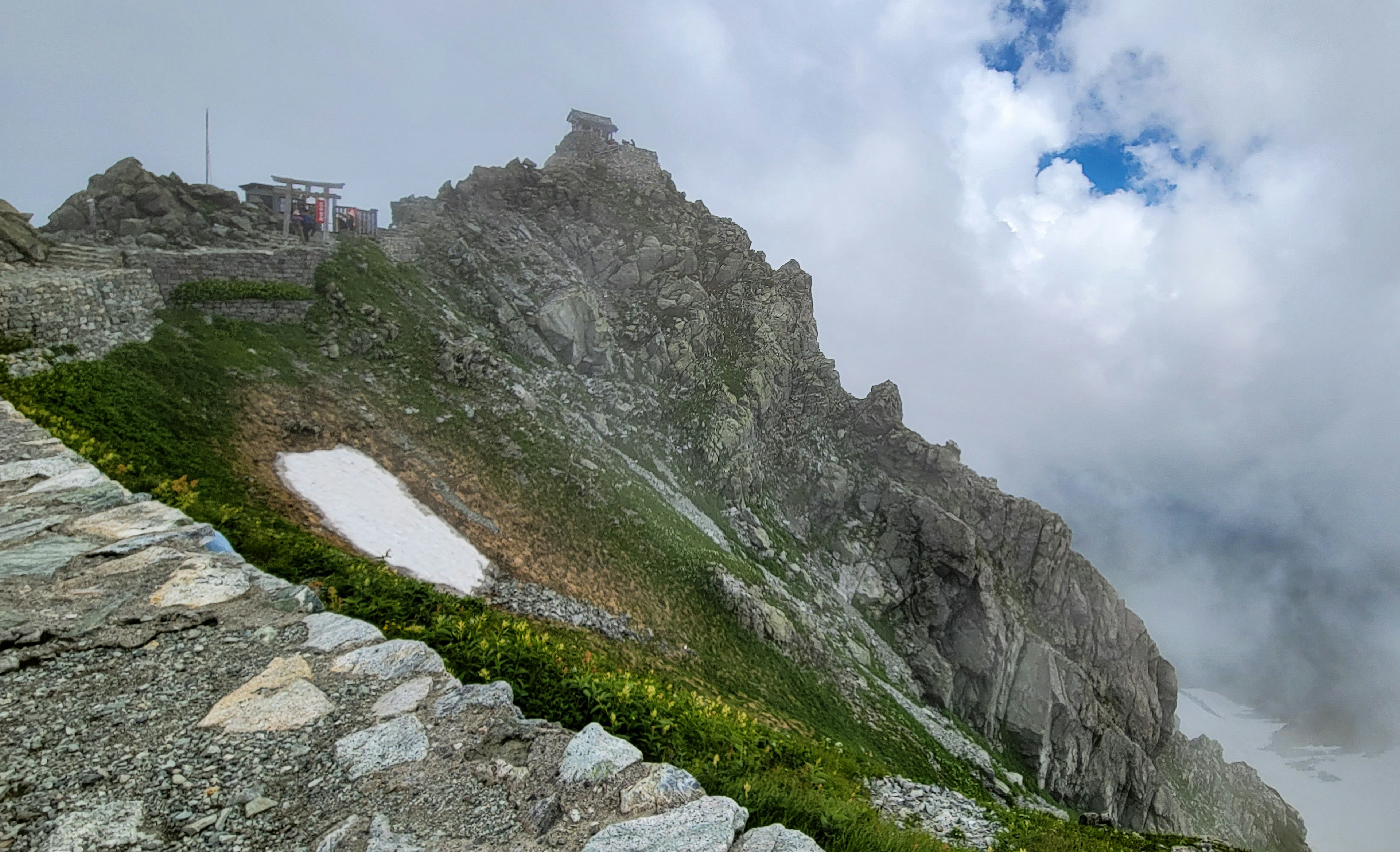 Pendiente de montaña con formaciones rocosas y niebla