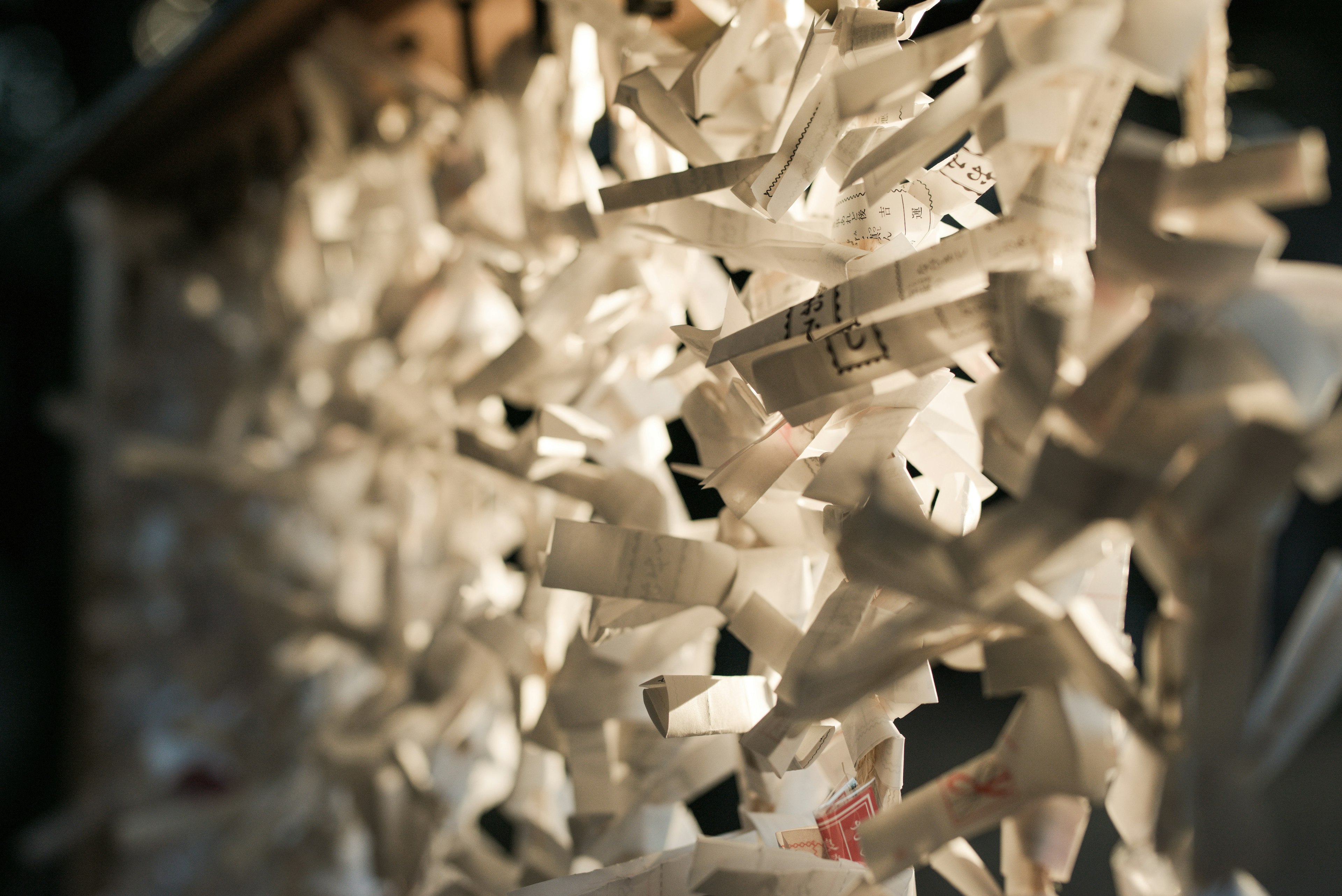 A decorative arrangement of white paper strips illuminated by light