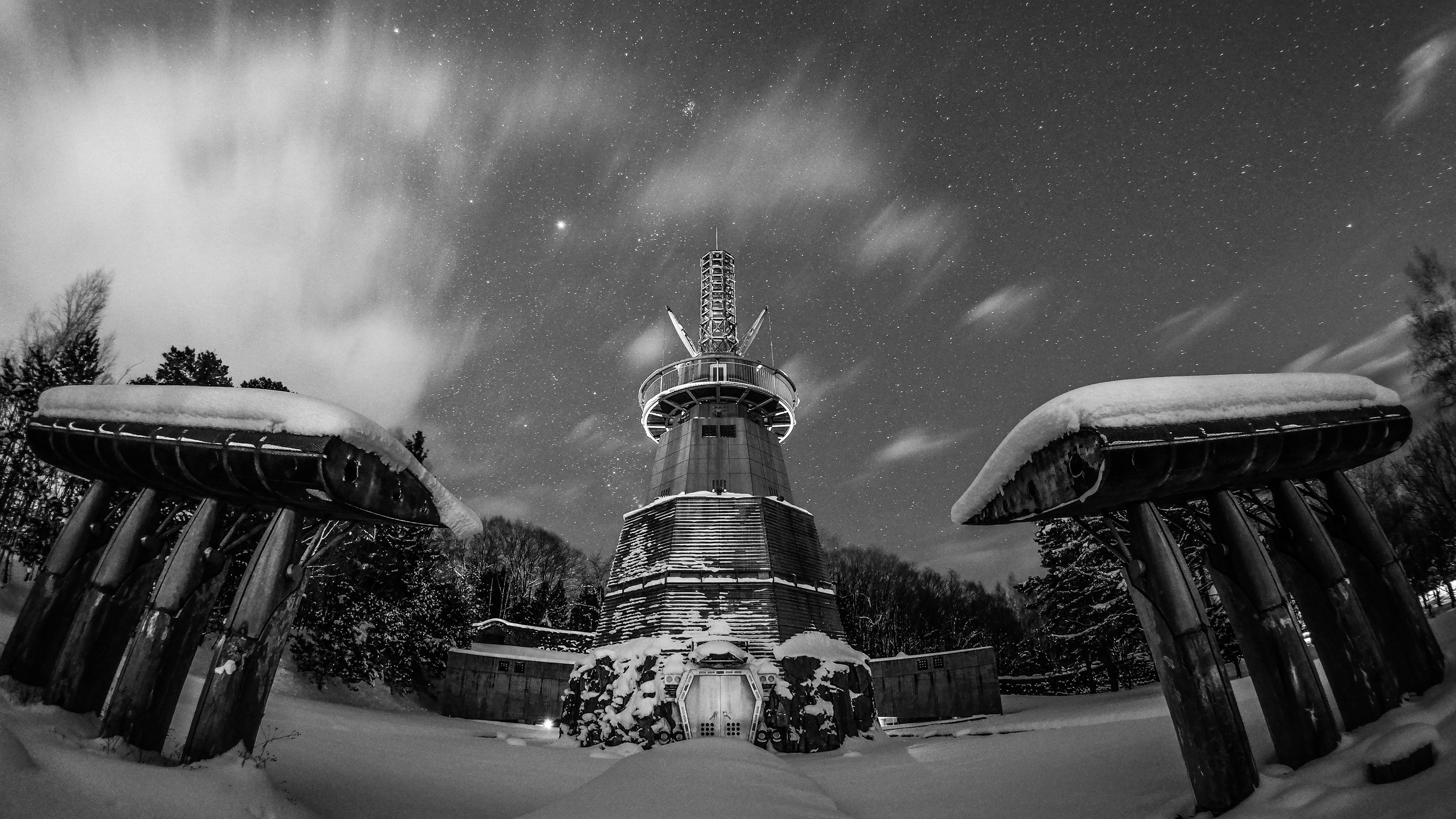 Schneeüberzogene Turm- und Toransicht mit leuchtenden Sternen am Nachthimmel