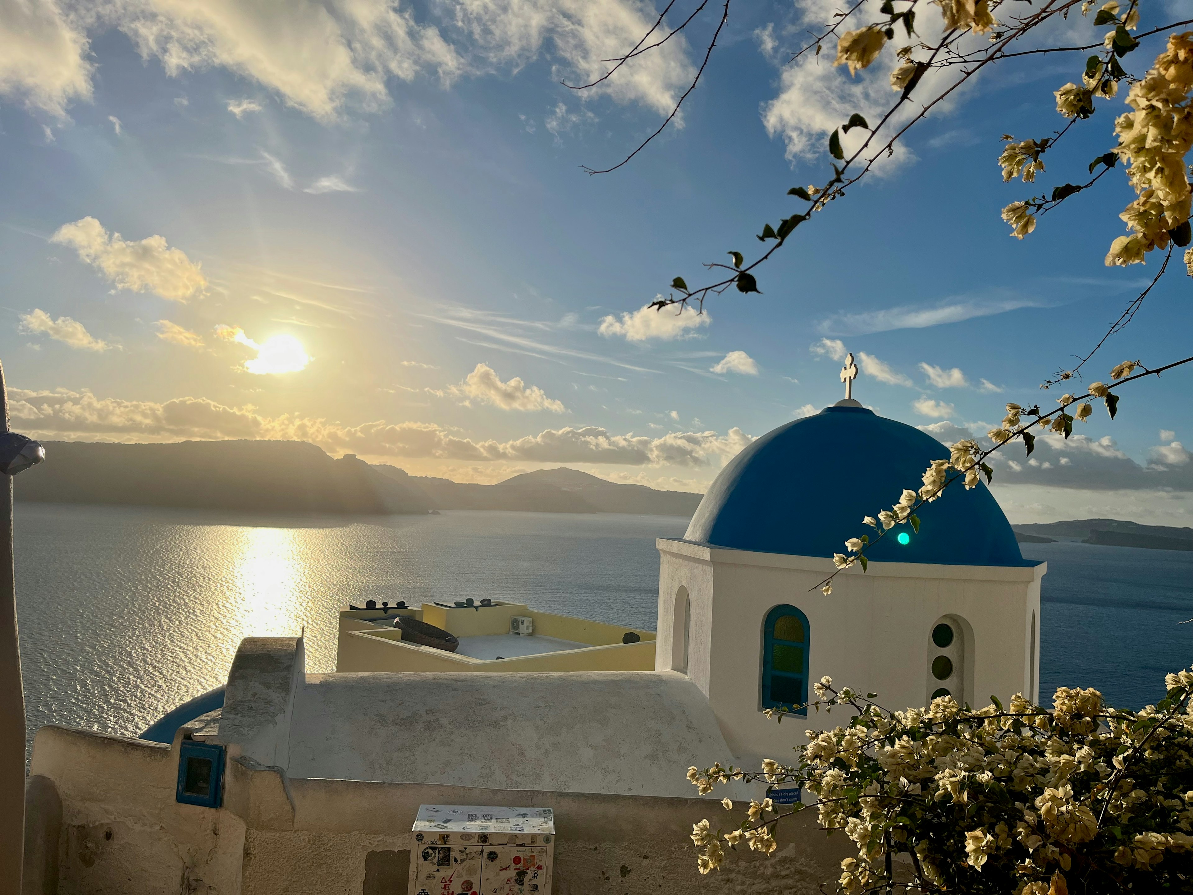 Bellissimo tramonto a Santorini con chiesa a cupola blu