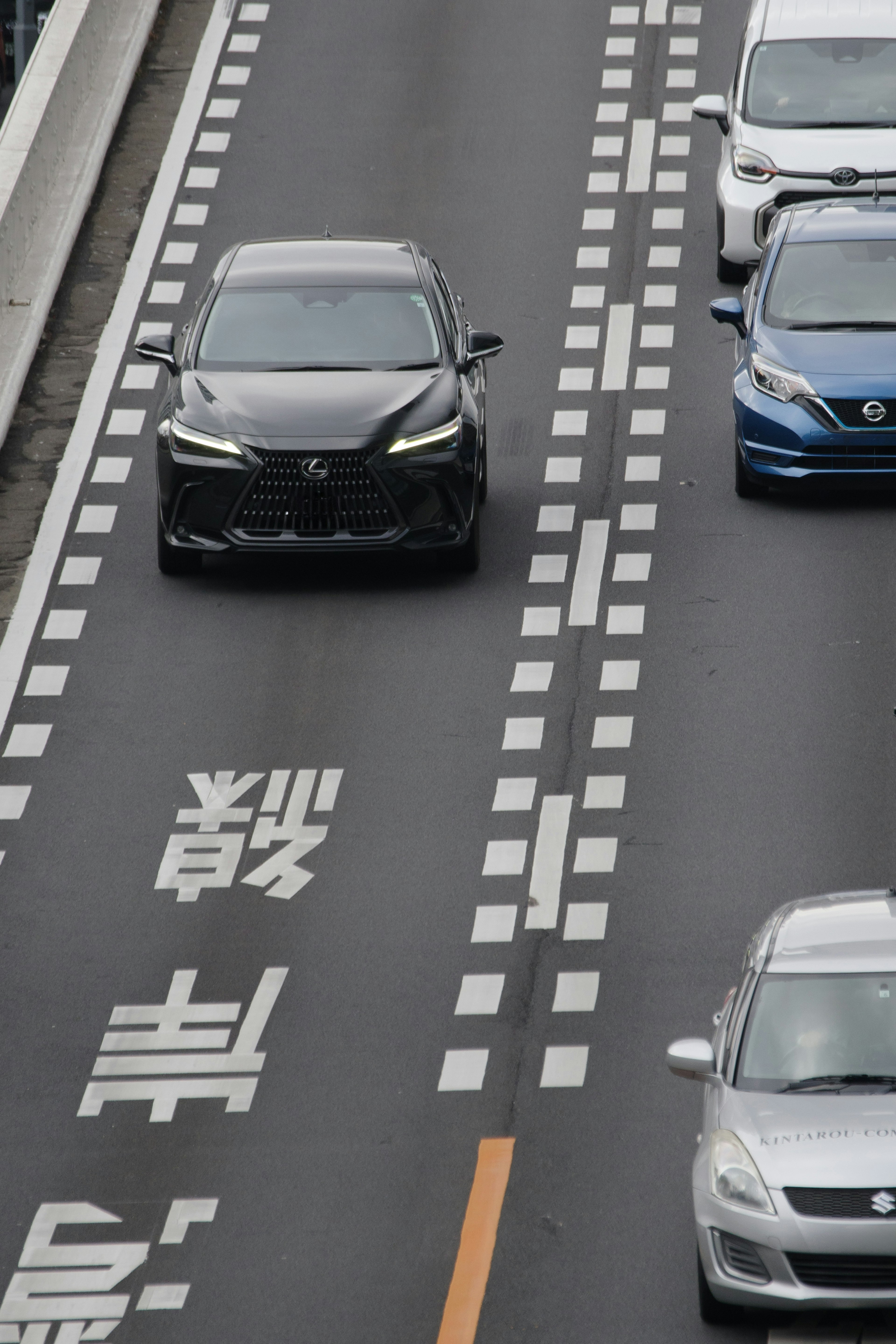 黒い車が高速道路を走行中で周囲に他の車が見える