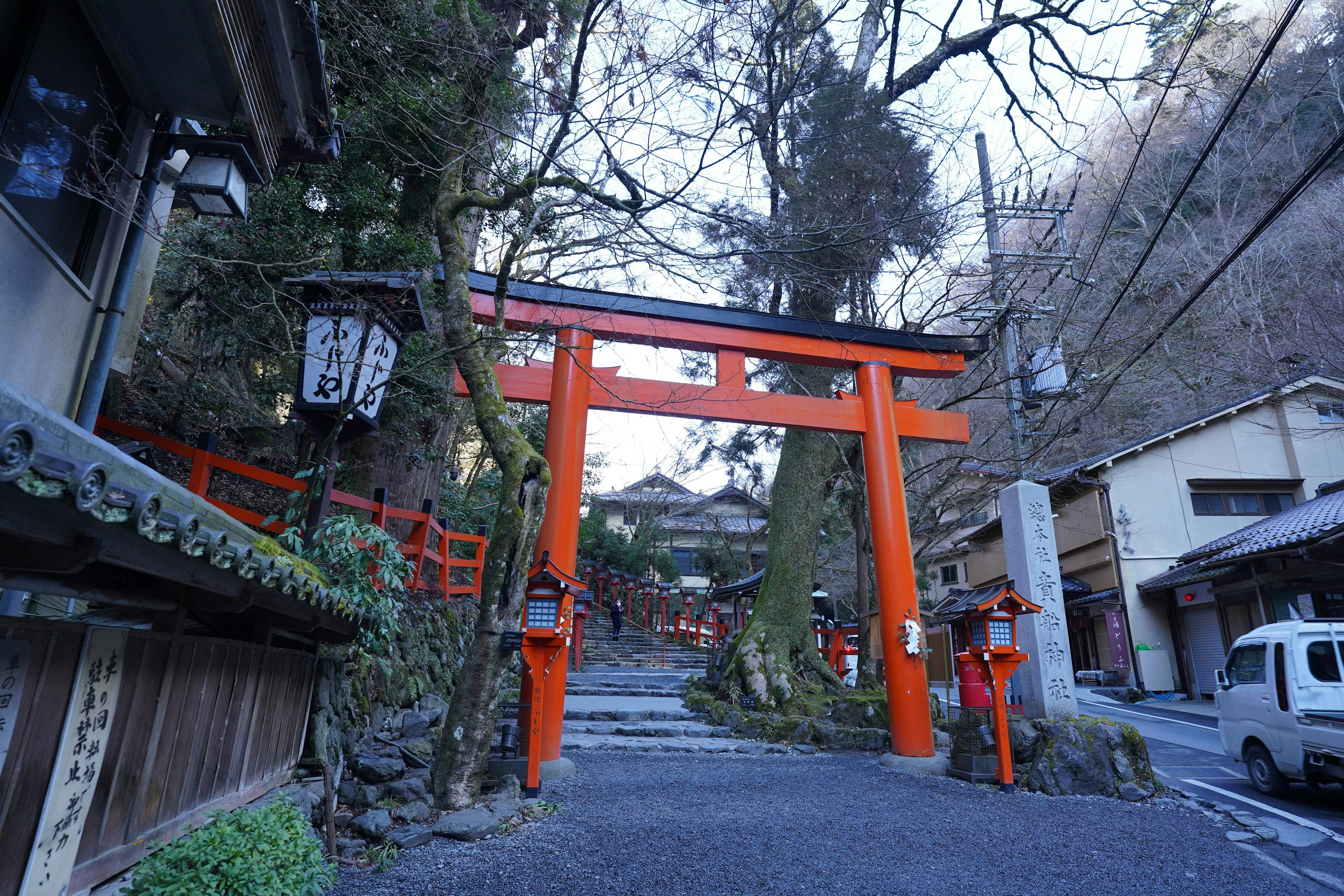 Gerbang torii tradisional Jepang dikelilingi oleh pohon dan bangunan