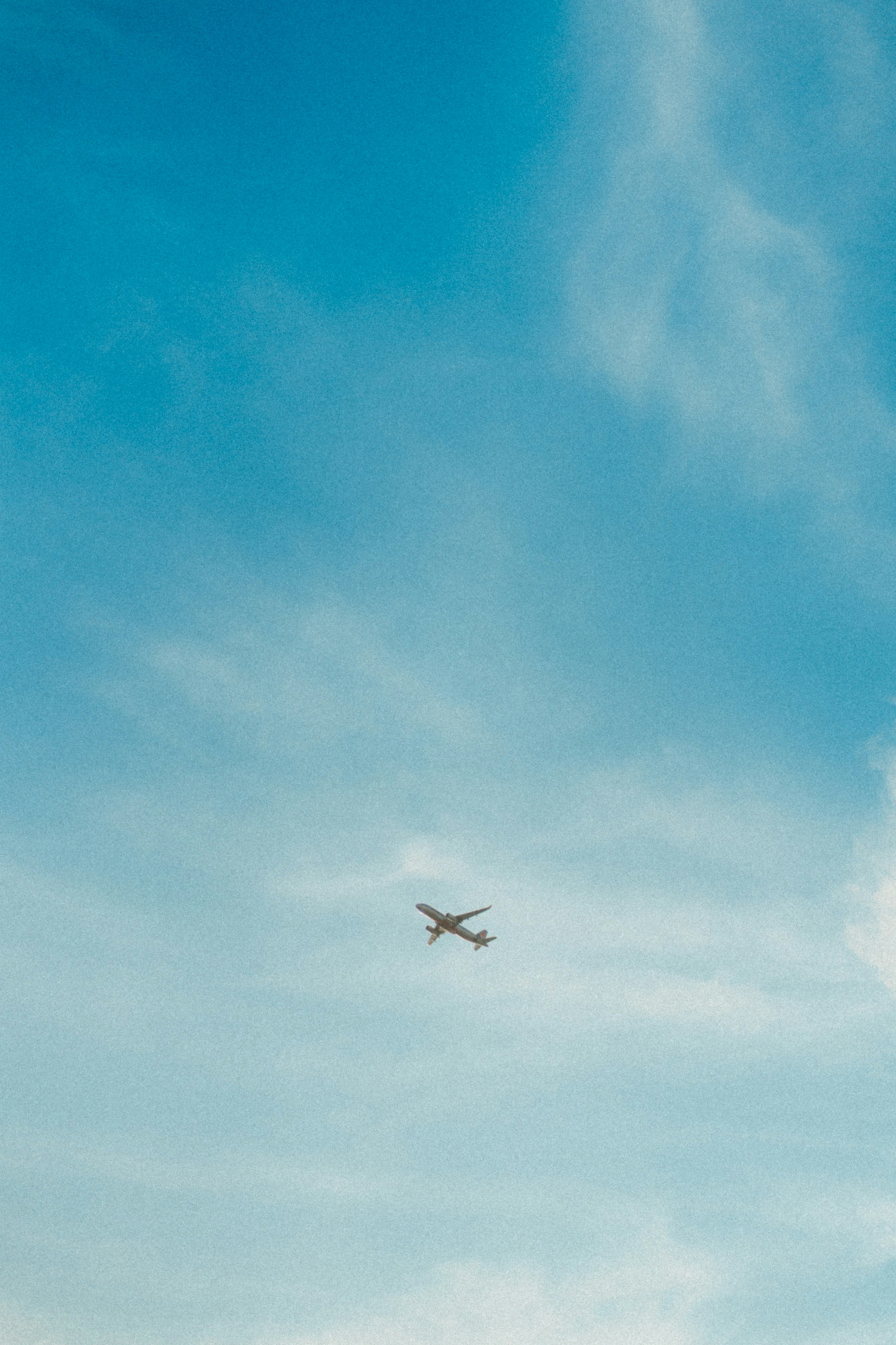 Avión volando en un cielo azul con nubes dispersas