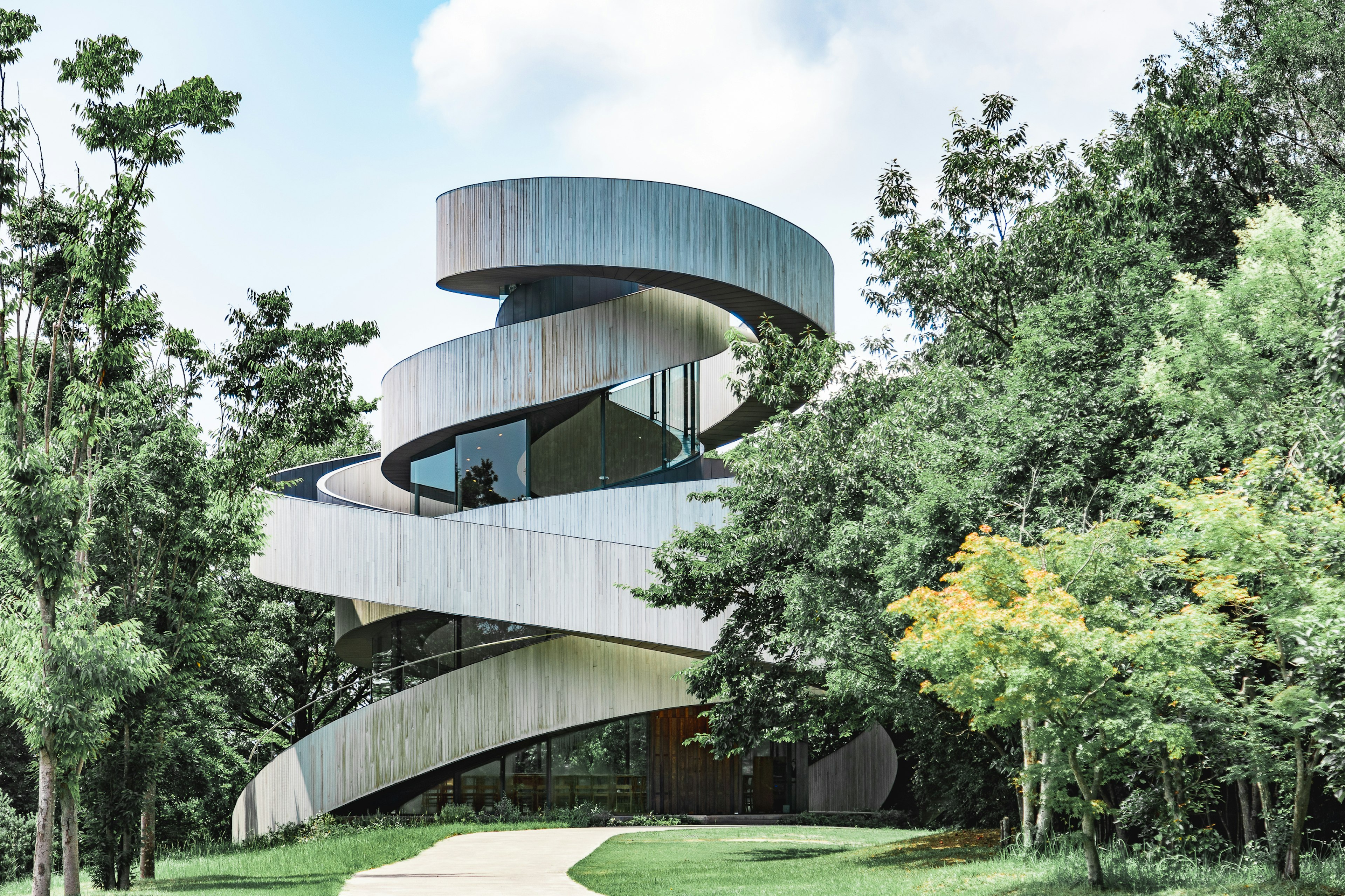 Unique spiral-shaped building surrounded by lush greenery