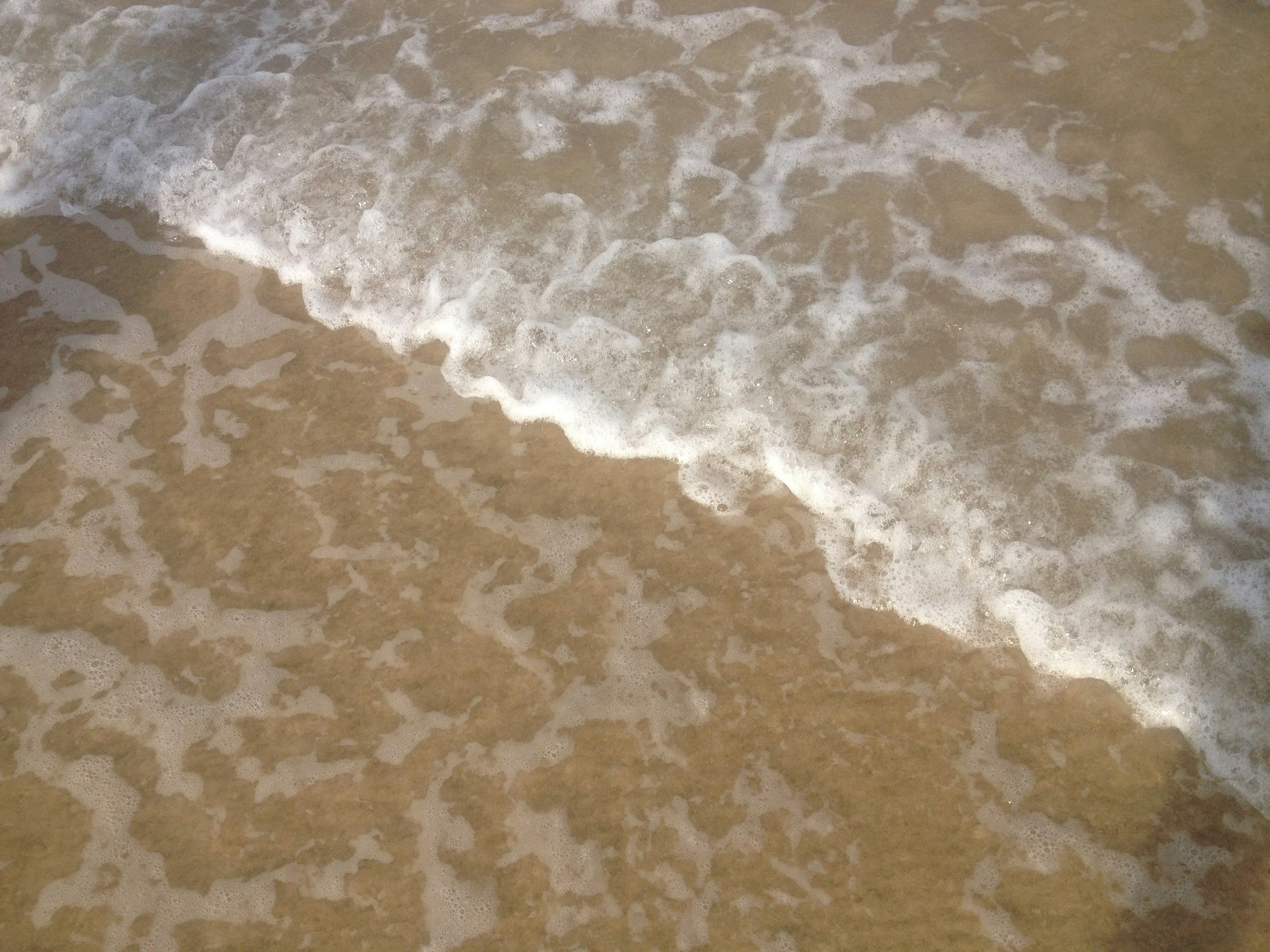 gelombang laut lembut bertemu pantai berpasir