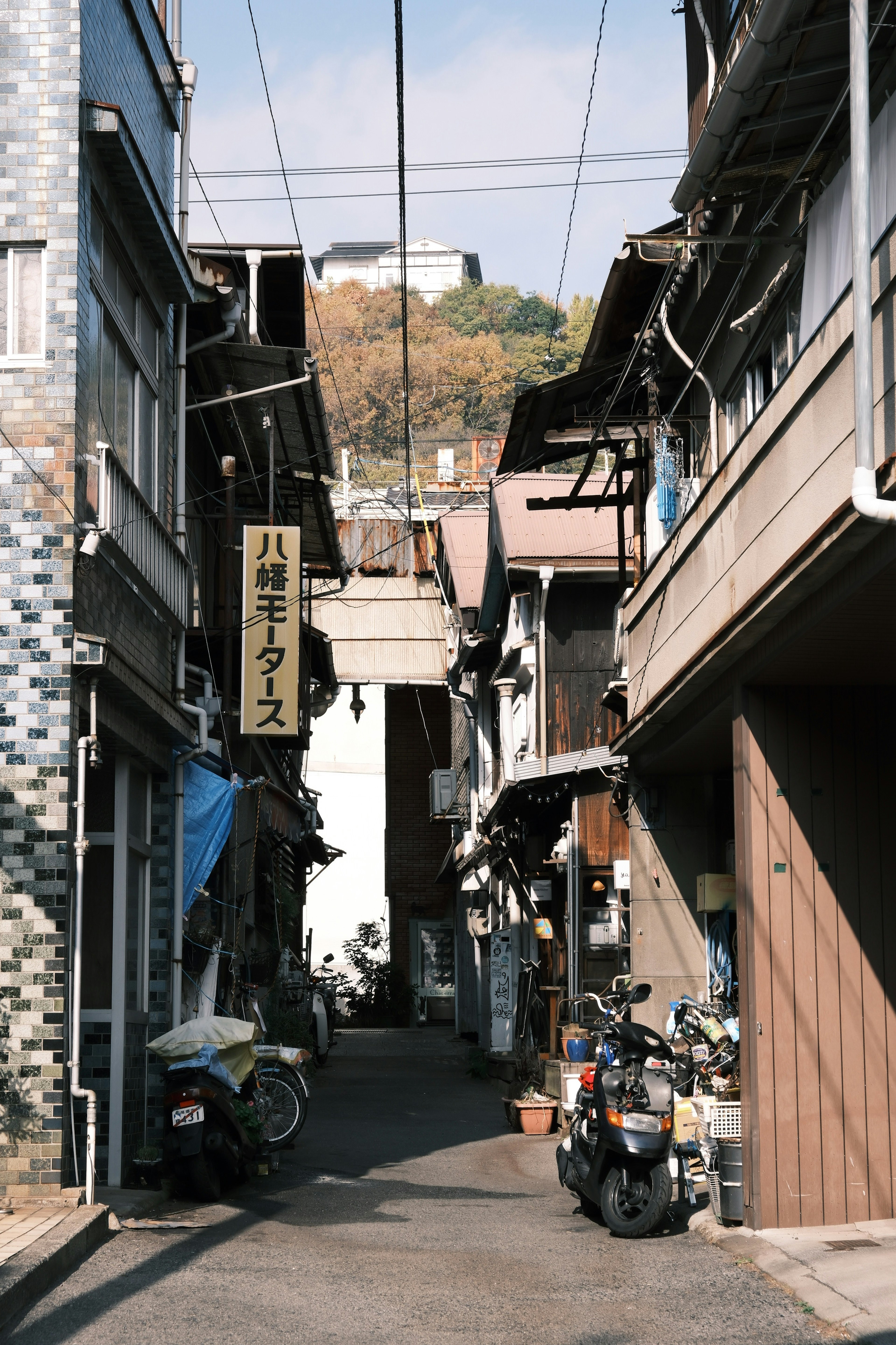 Callejón estrecho con edificios antiguos y motocicletas estacionadas