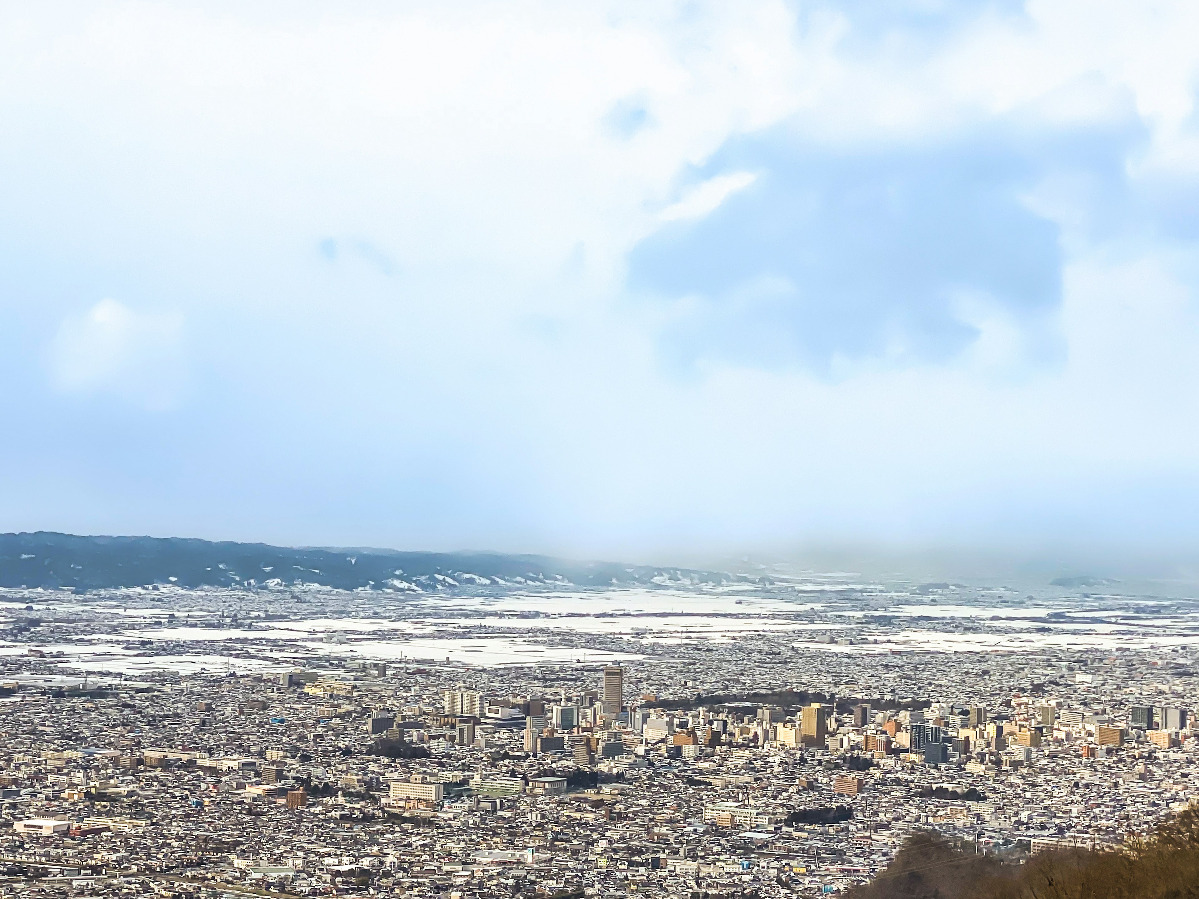 Panorama de la ciudad desde una montaña con nubes en el cielo azul