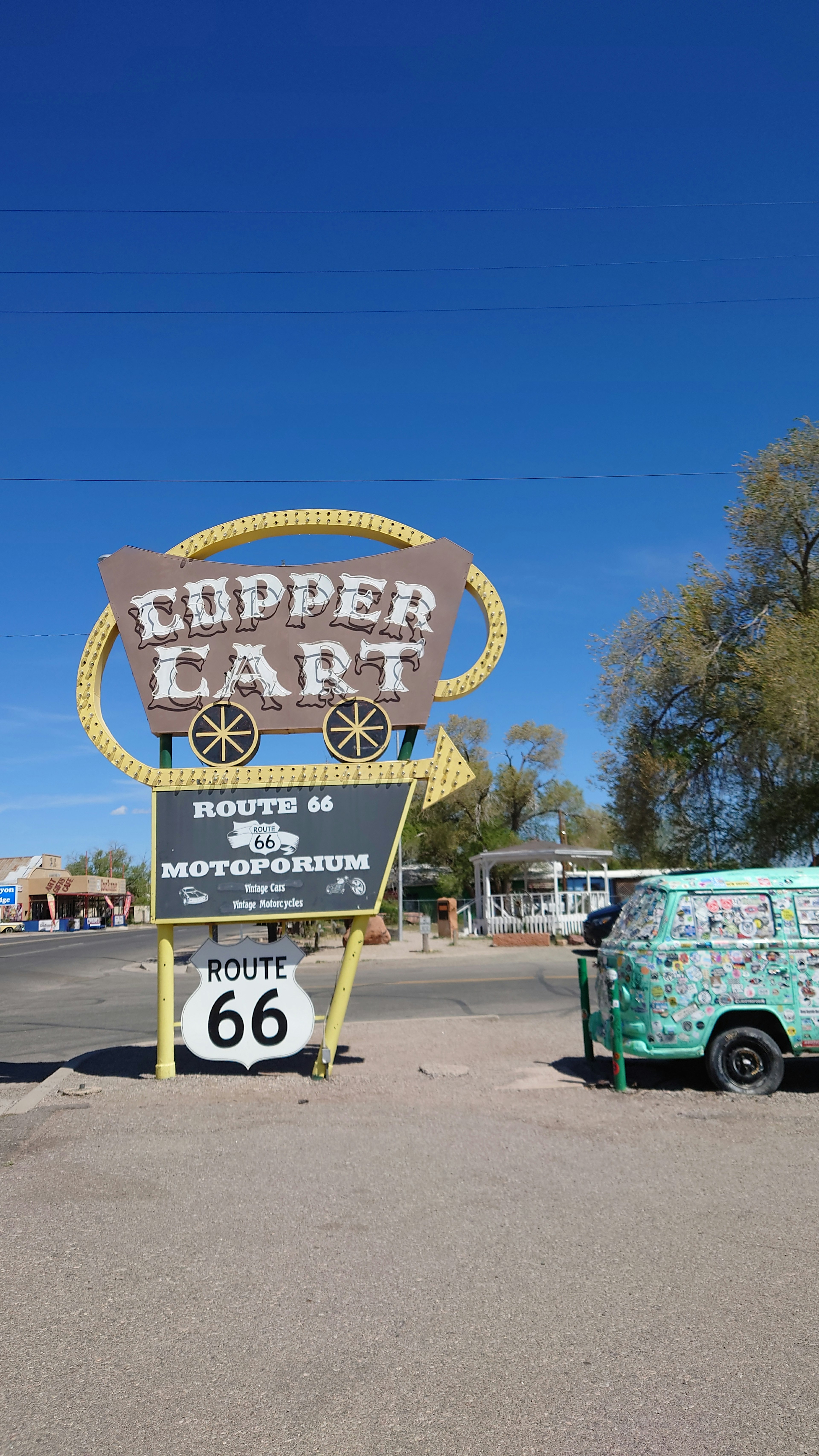 Tanda Chipper Cart dengan penanda Route 66 dan kendaraan berwarna