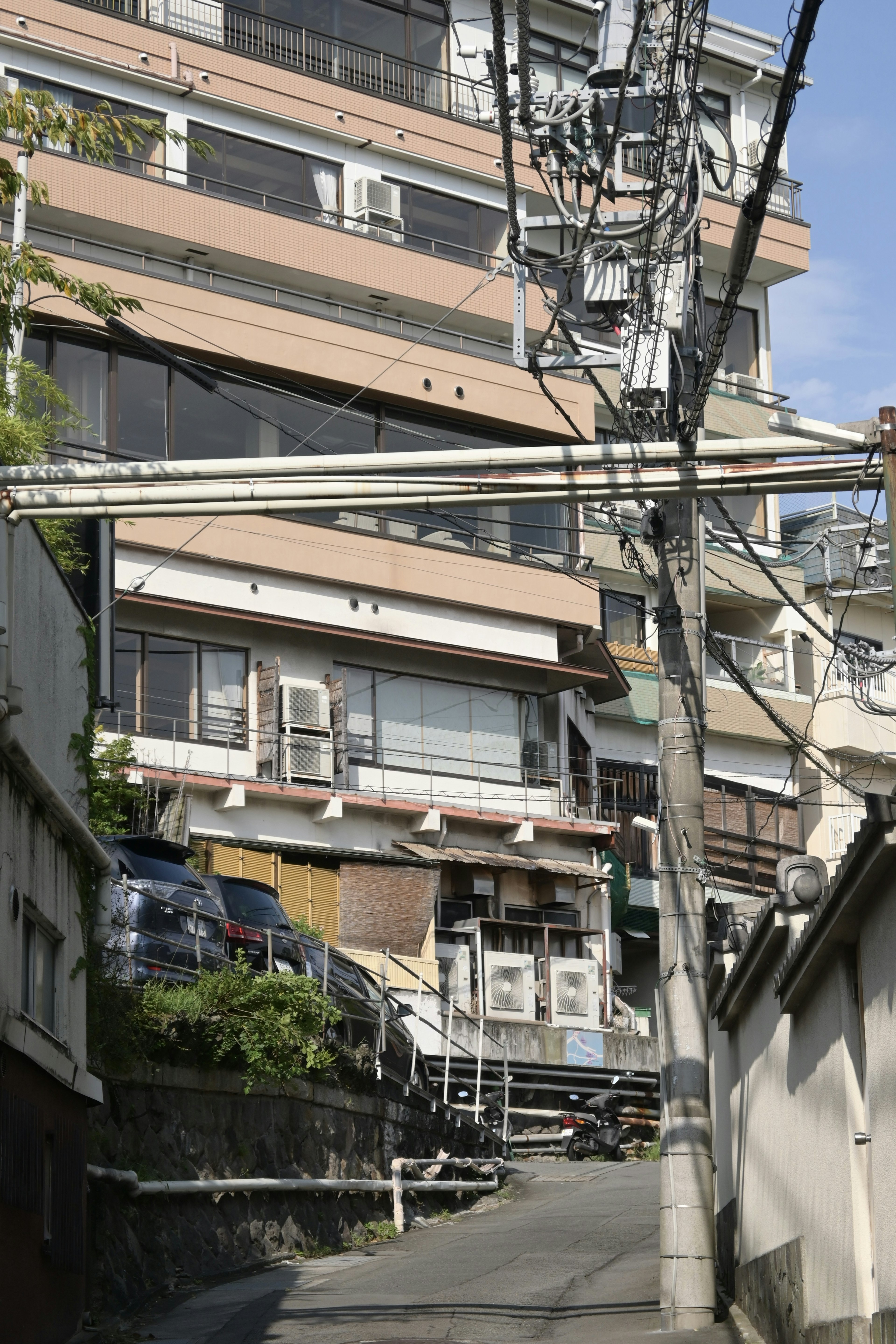 狭い道に沿った高層ビル群と電線の景観