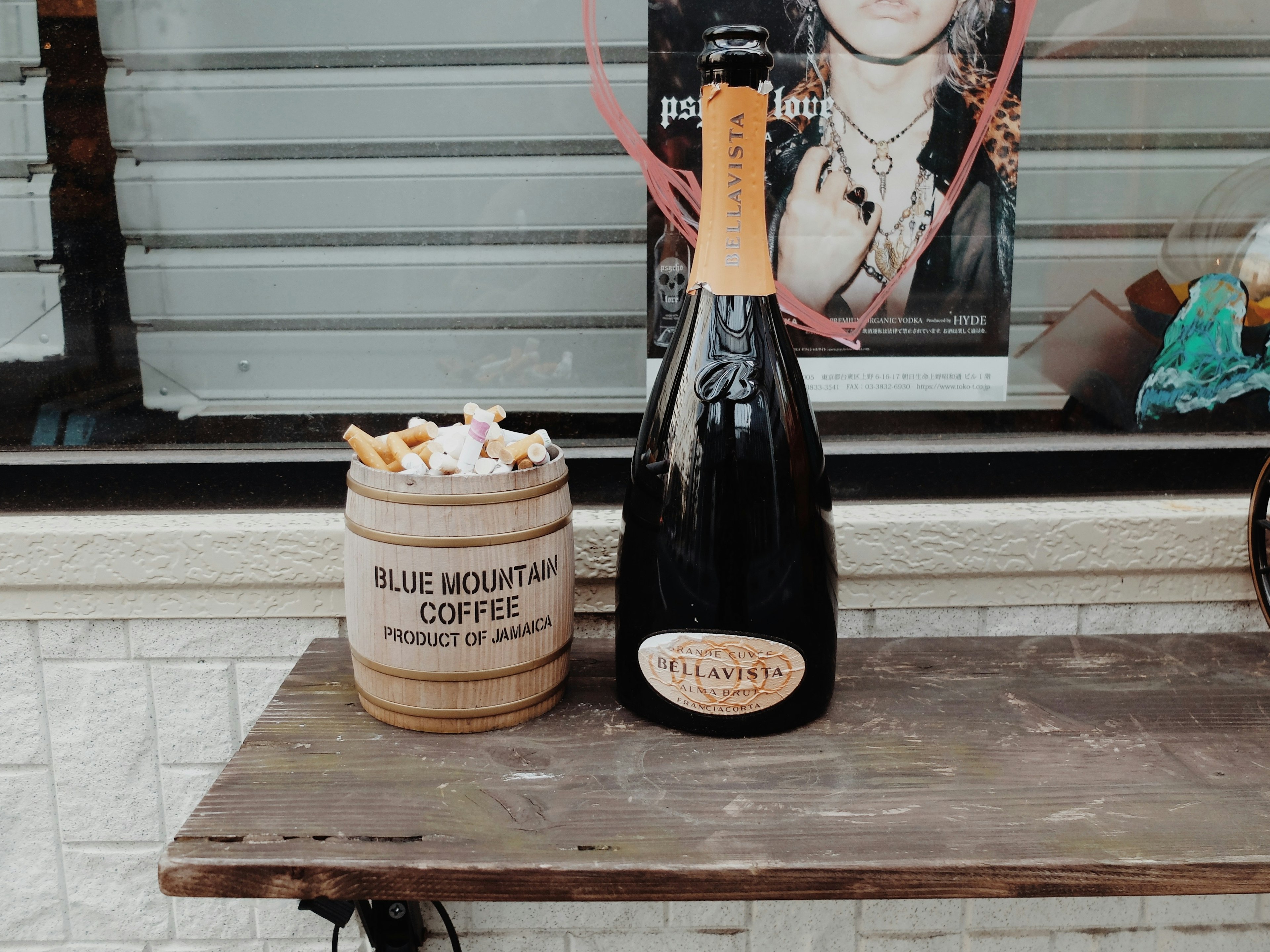 Une bouteille de champagne et un seau en bois de grains de café sur une table en bois