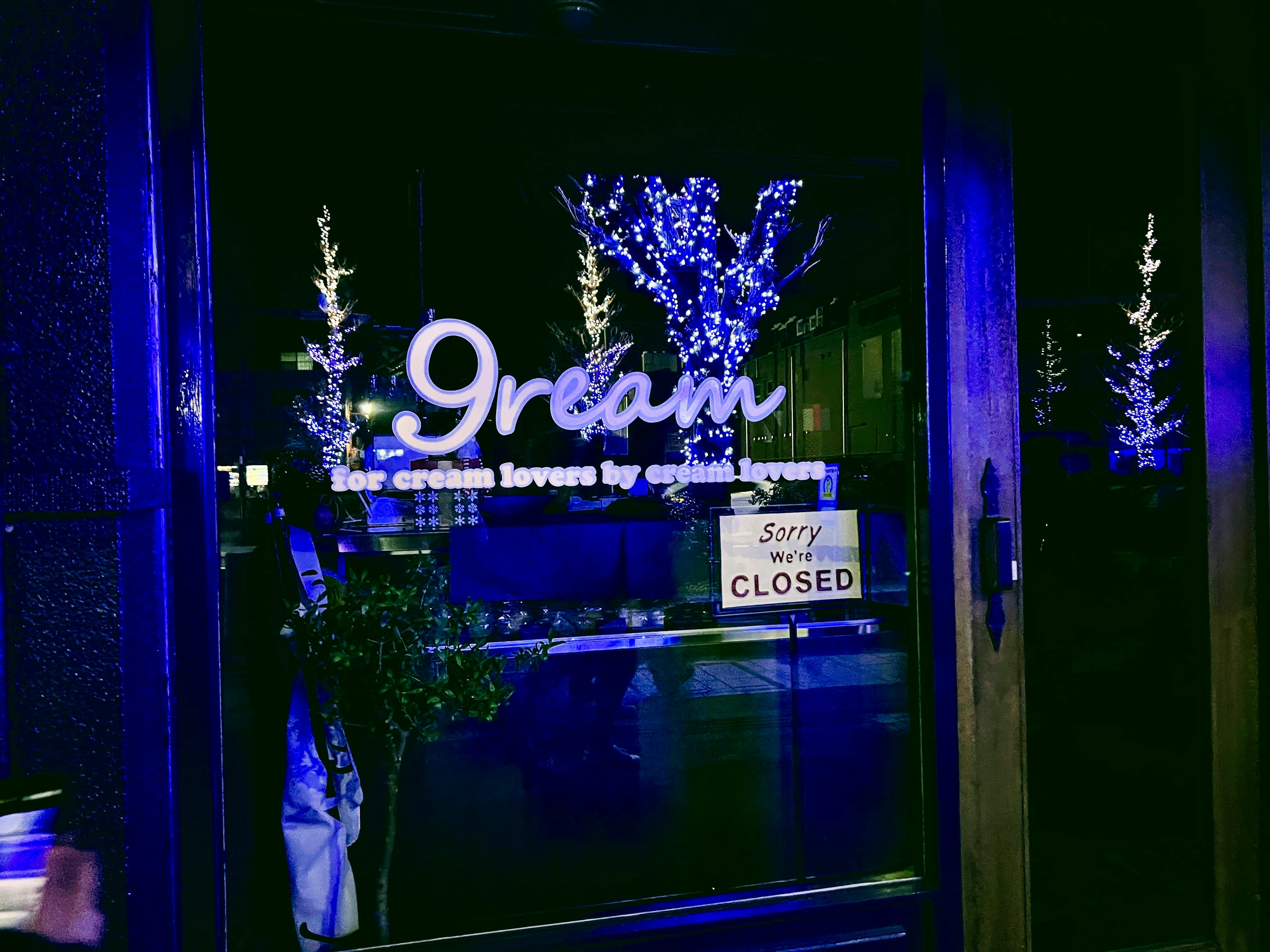 Entrata di una gelateria con illuminazione blu e cartello chiuso