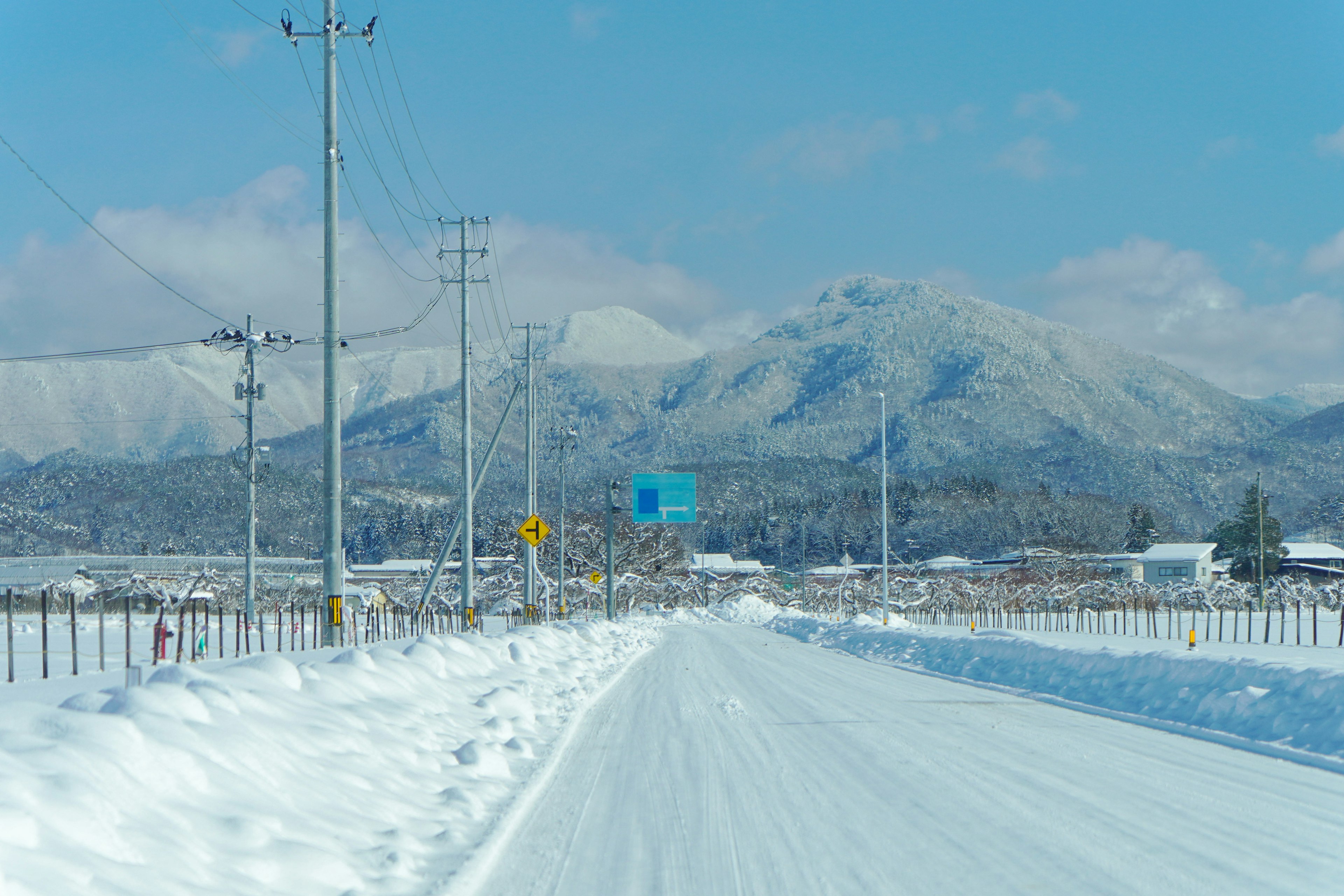 Snow-covered road with mountains in the background