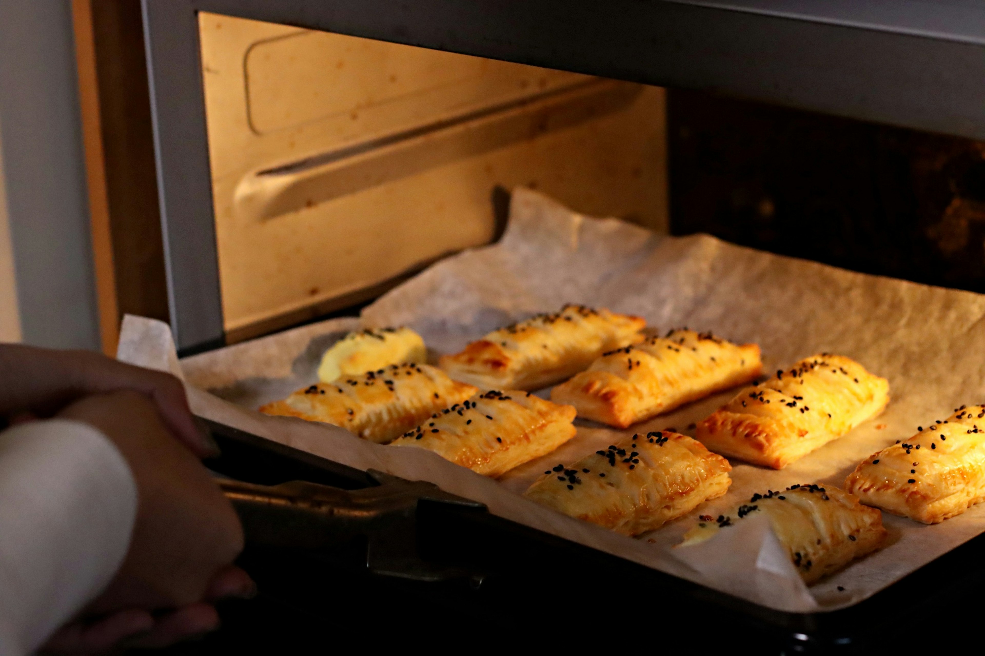 Pasteles dorados horneándose en el horno sobre papel pergamino