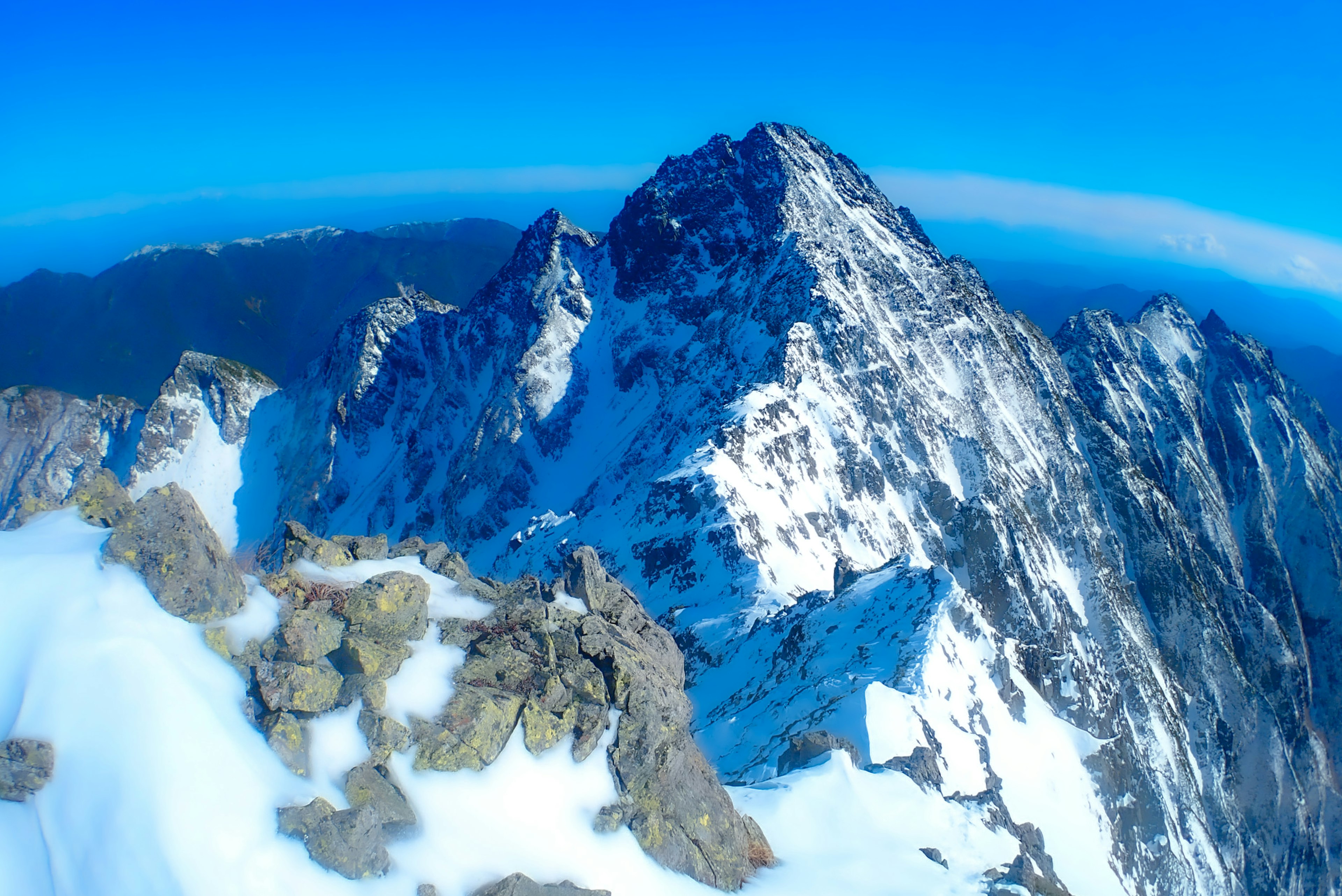 Vue imprenable sur un sommet de montagne enneigé sous un ciel bleu clair