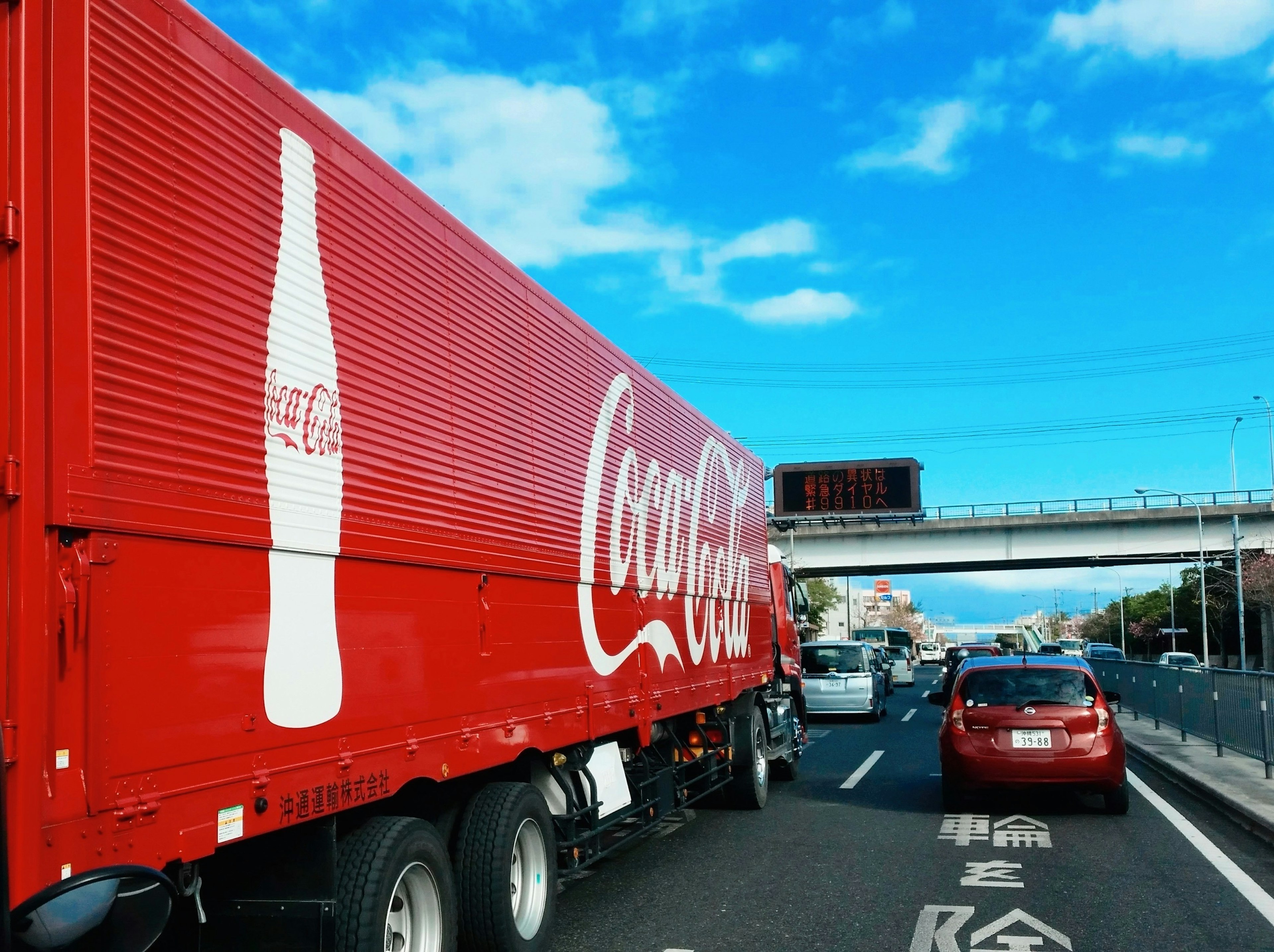 赤いコカ・コーラのトラックが高速道路を走行中