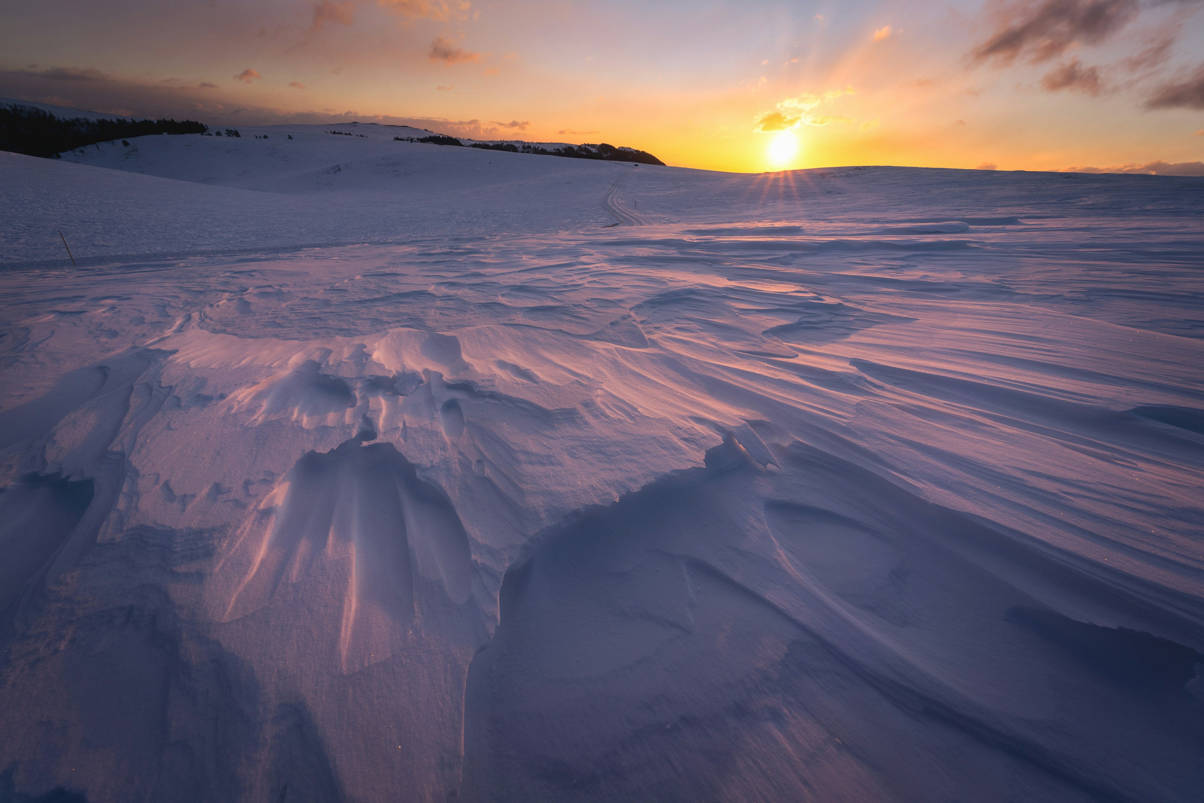 Schöne verschneite Landschaft mit Sonnenuntergangs-Kontrast